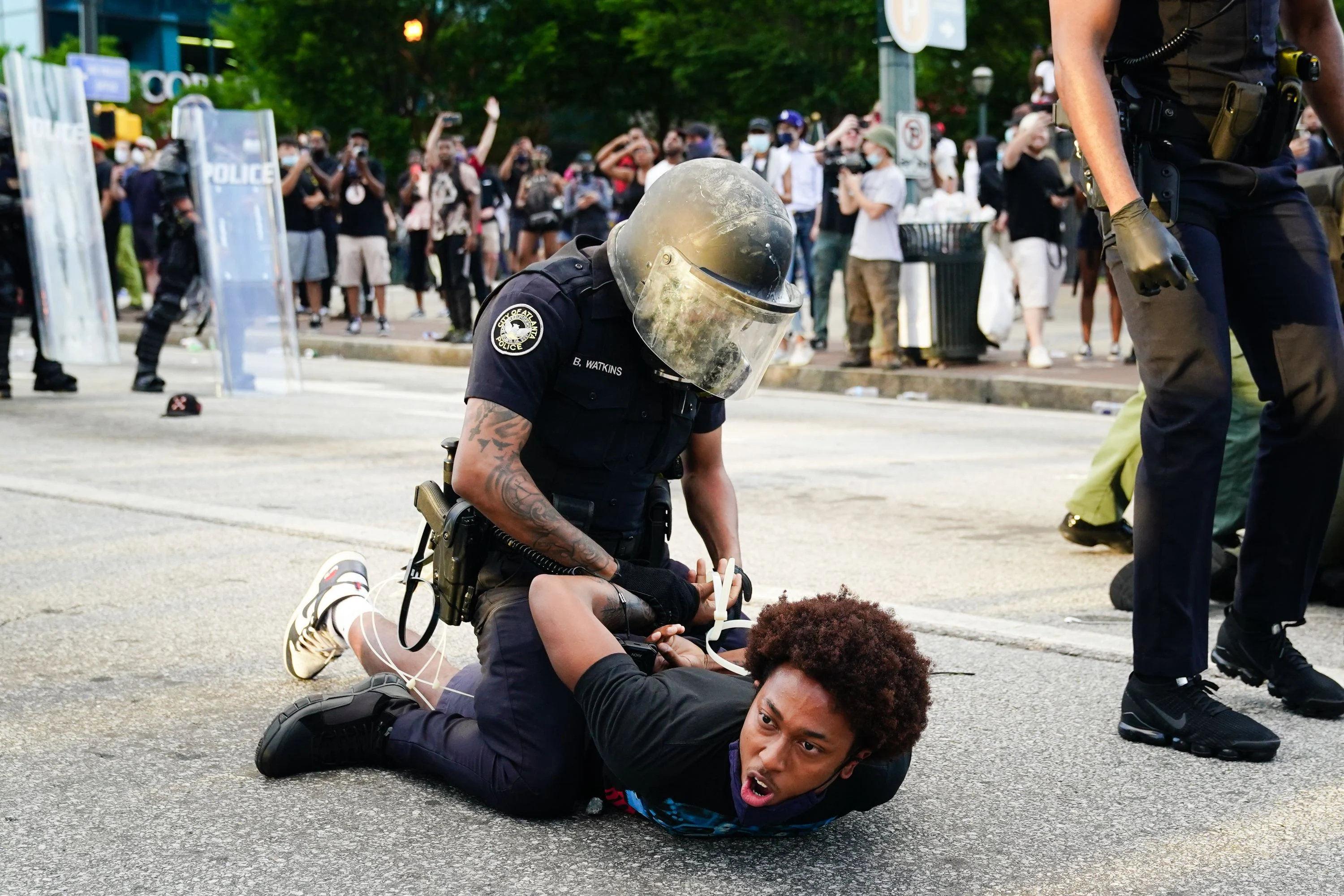 A policeman in riotgear arrests a protestor
