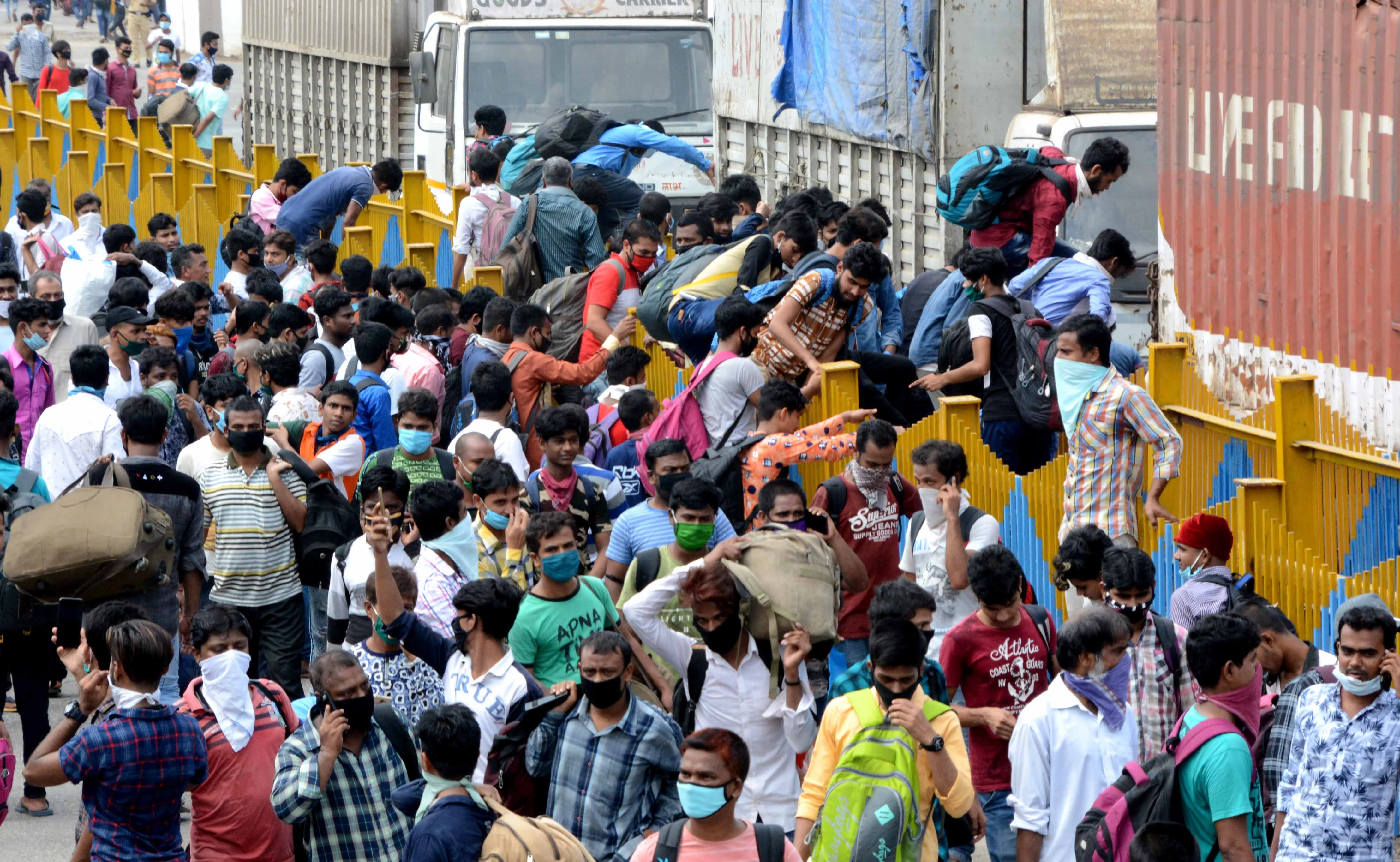 Long way home: Migrants queue for train tickets at Mumbai
