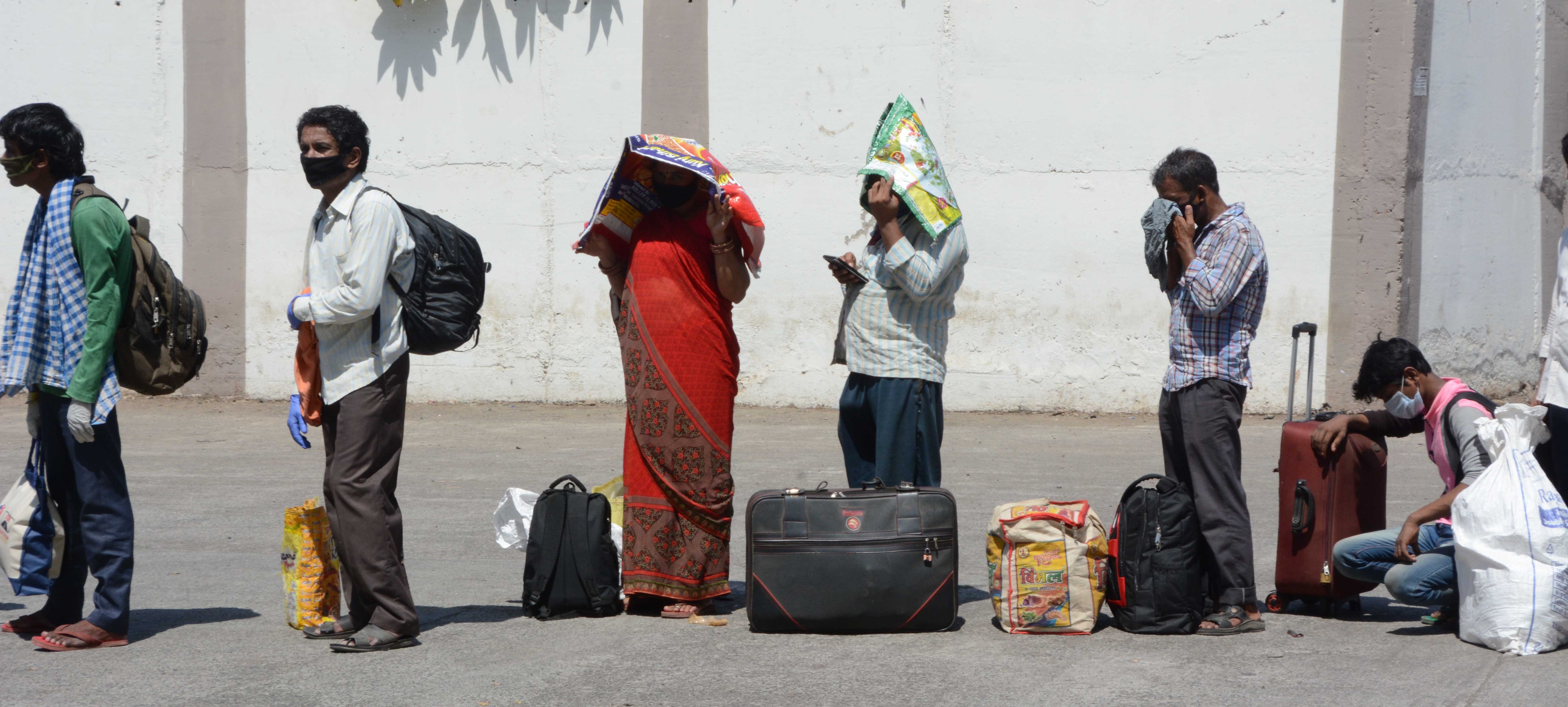 Long way home: Migrants queue for train tickets at Mumbai