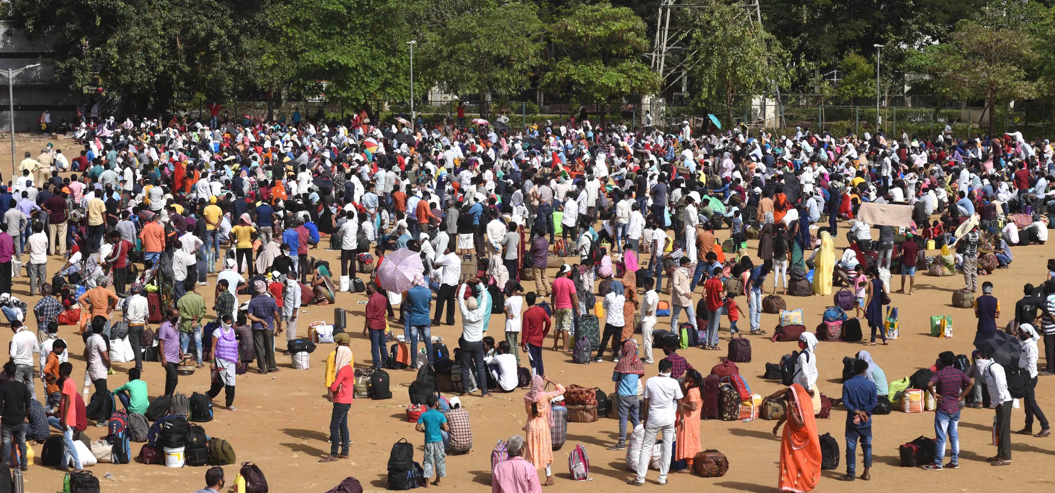 Long way home: Migrants queue for train tickets at Mumbai