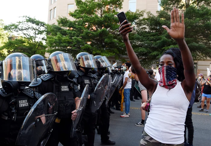 A protester holds up his hands in front of a row of police officers during a demonstration against the death of George Floyd at a park near the White House on June 1, 2020 in Washington, DC