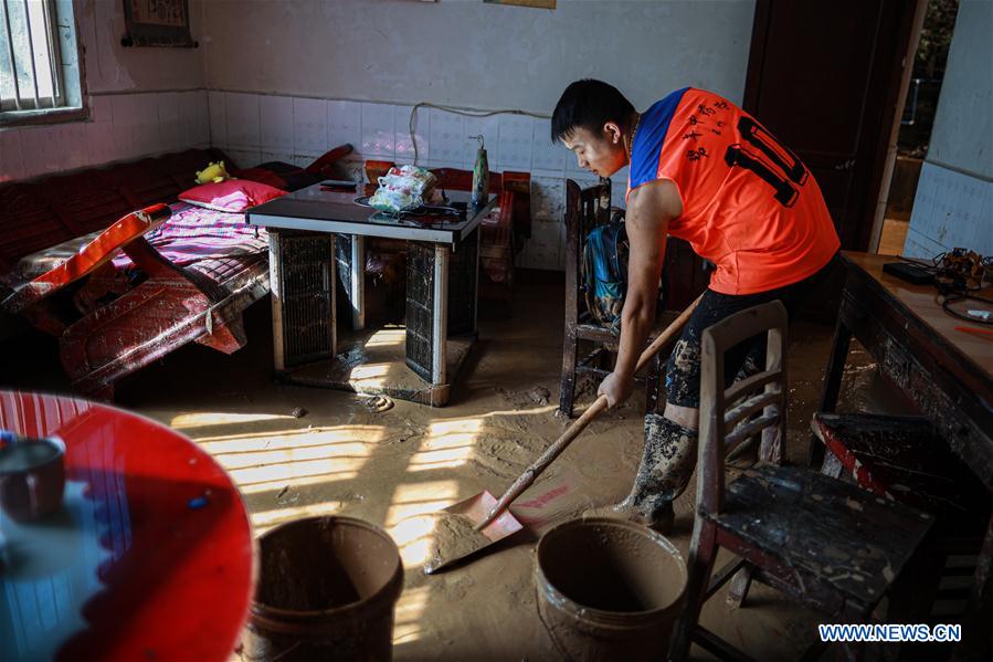 A resident cleans silt at his home in Bifeng Town of Zheng'an County in Zunyi, southwest China's Guizhou Province, June 13, 2020. Rain-triggered floods have affected more than 700,000 people in southwest China's Guizhou Province, with 29,500 individuals temporarily evacuated, authorities said Saturday.