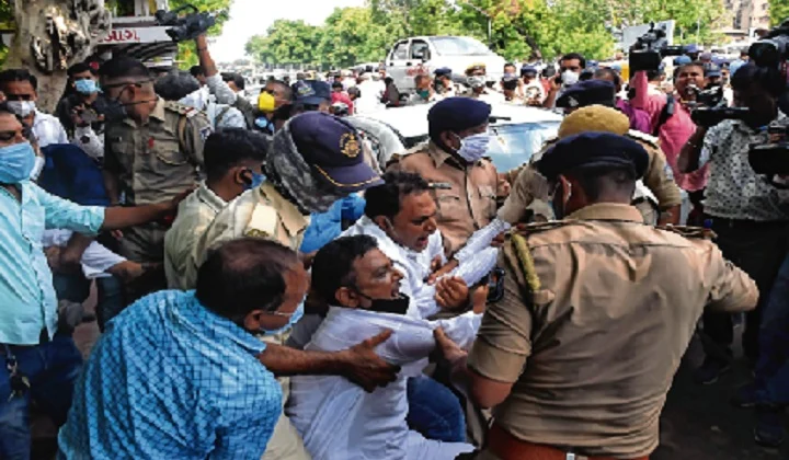 A Gujarat Congress supporter shouts anti-government slogans as cops detain him in Ahmedabad on Monday.