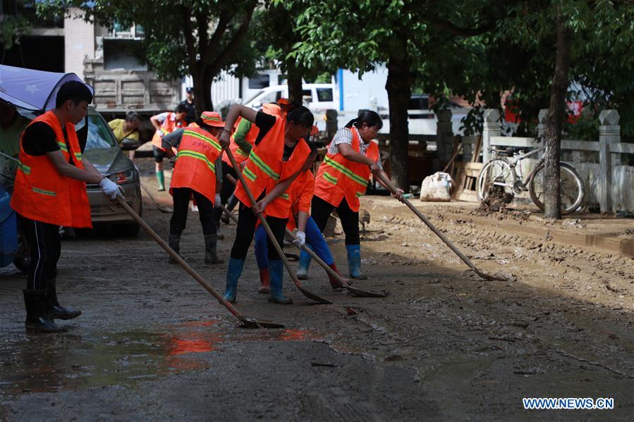 Rescuers clean silt on the street in Bifeng Town of Zheng'an County in Zunyi, southwest China's Guizhou Province, June 13, 2020. Rain-triggered floods have affected more than 700,000 people in southwest China's Guizhou Province, with 29,500 individuals temporarily evacuated, authorities said Saturday.