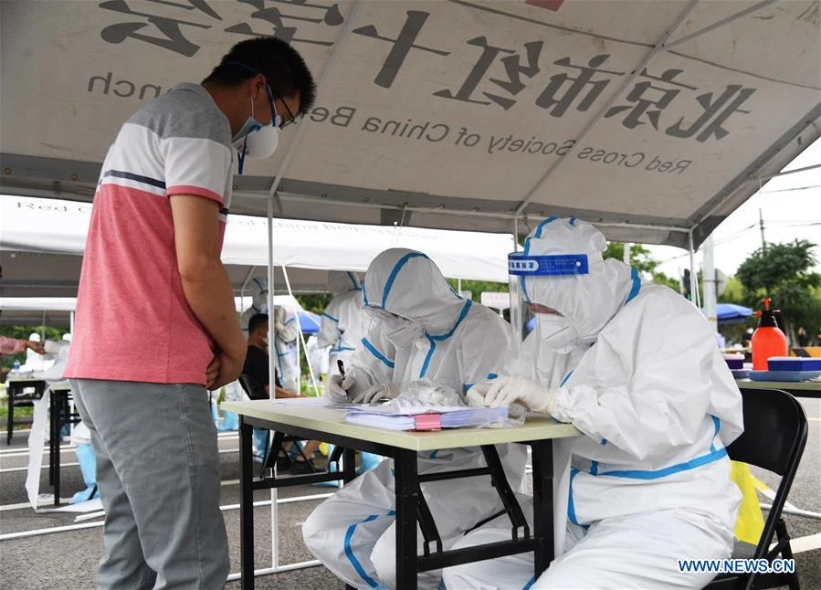 Staff members record the information of a resident (1st L) to conduct nucleic acid test at a sampling site in Fengtai District of Beijing, capital of China, June 15, 2020. Beijing on Sunday conducted nucleic acid tests on 76,499 people, with 59 testing positive for COVID-19, according to a press conference held Monday. As of 6 a.m. Monday, 193 sampling sites had been set up across Beijing to facilitate nucleic acid testings, said Gao Xiaojun, spokesperson for the municipal health commission.