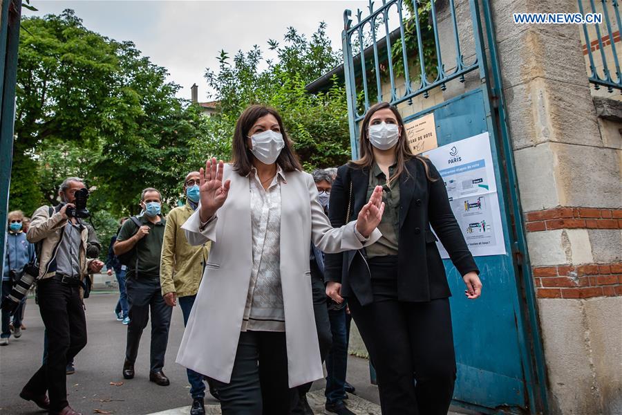 The incumbent Mayor of Paris Anne Hidalgo (L, front) leaves a polling station of the 15th district during the second round of municipal elections in Paris, France, June 28, 2020.