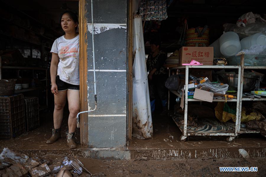 A resident is seen at the gate of her house in Bifeng Town of Zheng'an County in Zunyi, southwest China's Guizhou Province, June 13, 2020. Rain-triggered floods have affected more than 700,000 people in southwest China's Guizhou Province, with 29,500 individuals temporarily evacuated, authorities said Saturday.