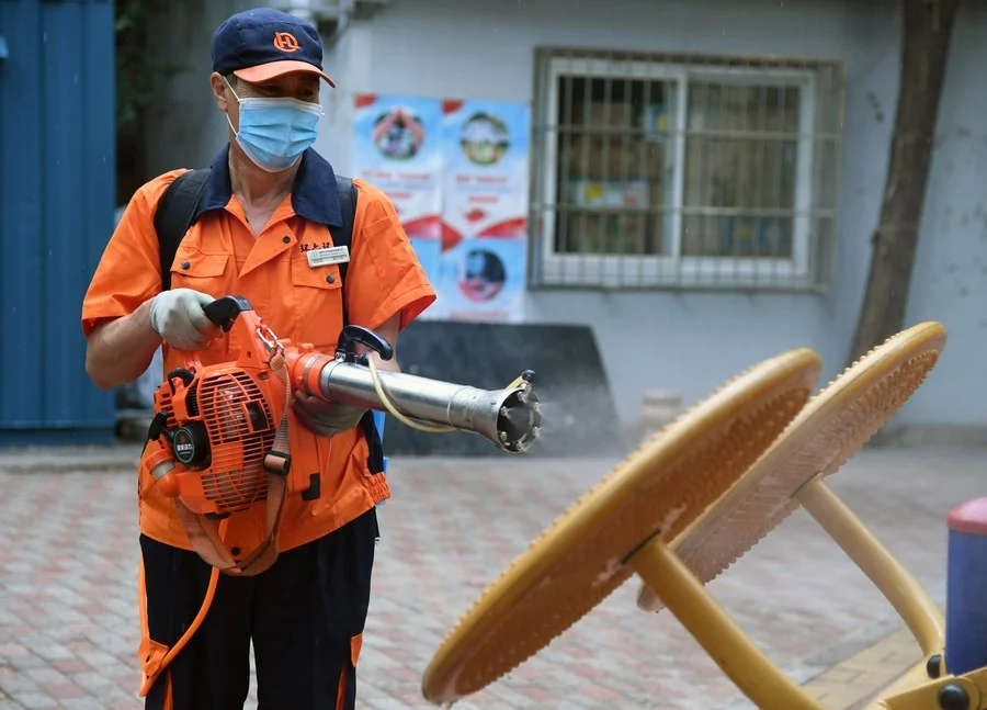 A worker disinfects fitness equipment at a community in Balizhuang Street of Haidian District, Beijing, capital of China, June 23, 2020