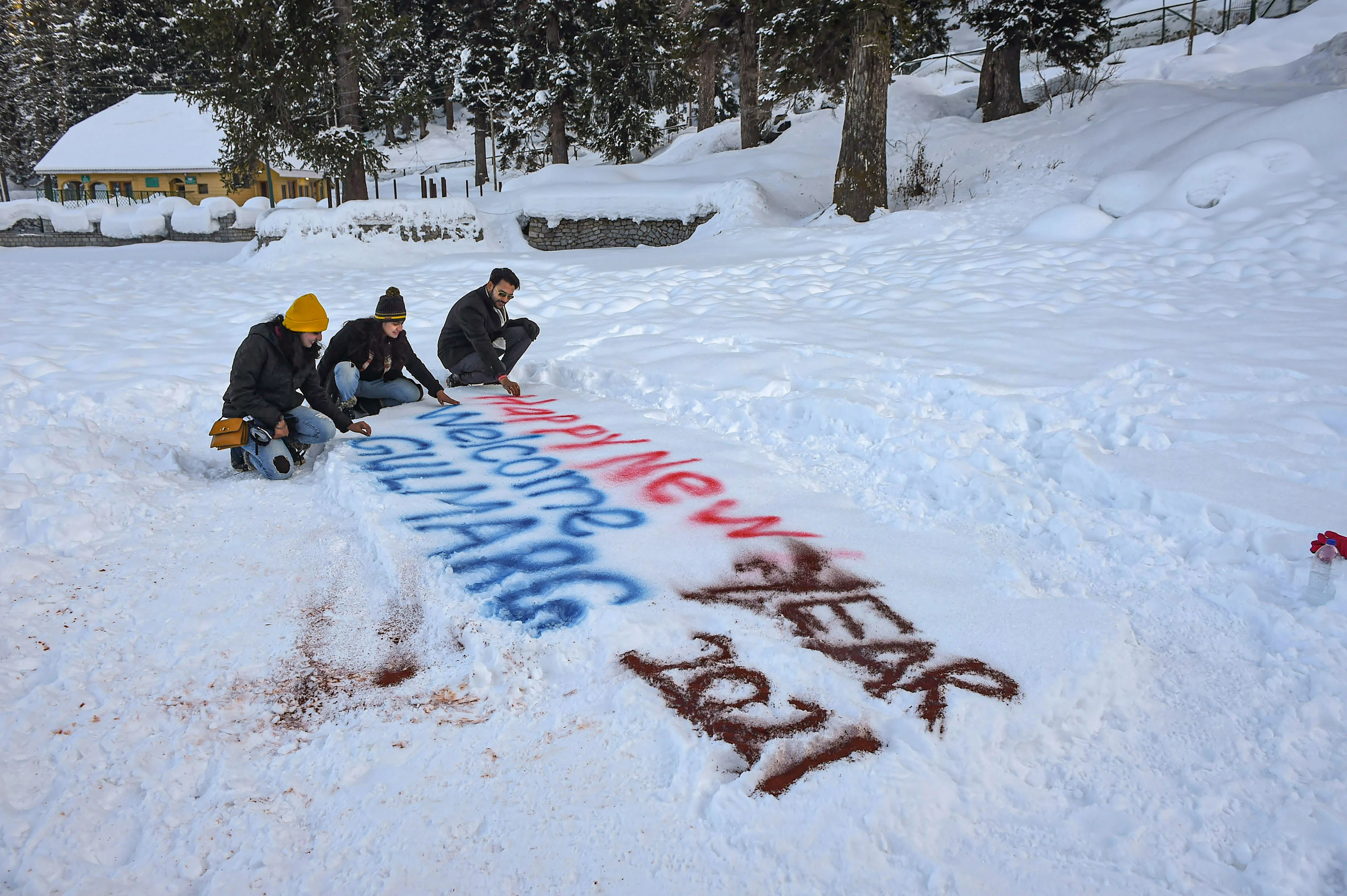 Gulmarg: Tourists sit near Happy New Year 2021 sign on snow at the famous ski resort of Gulmarg in north Kashmir on the eve of the New Year, Thursday, Dec. 31, 2020. The resort is witnessing a huge rush of visitors, with most of them not adhering to social distancing norms and other COVID-19 related precautions.