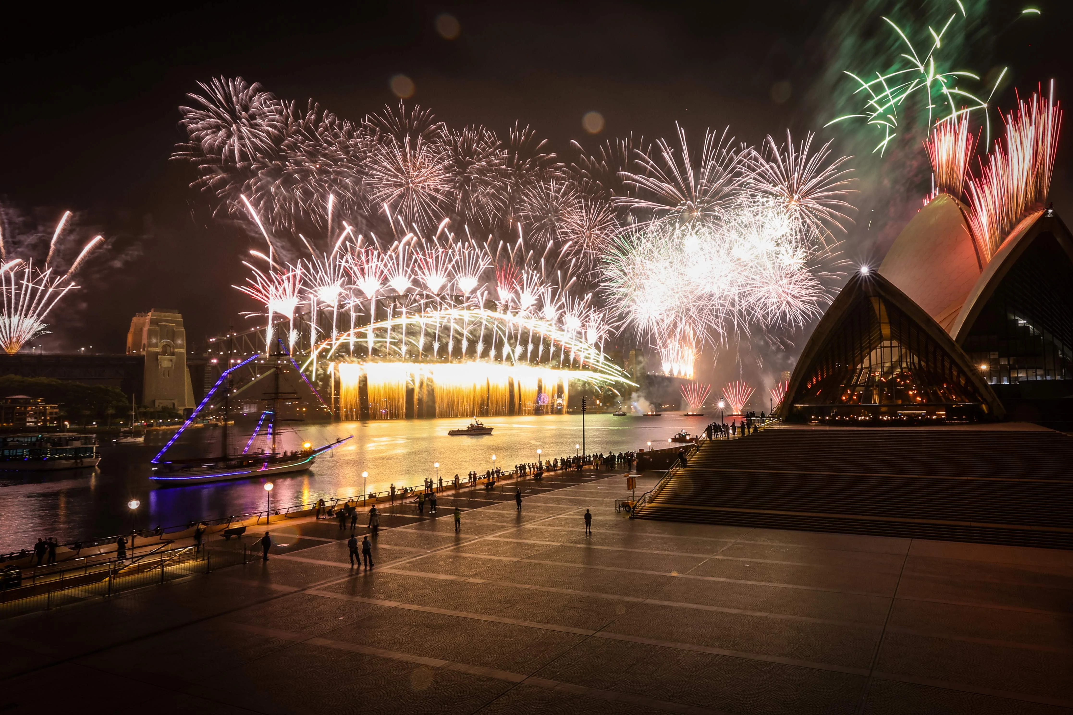 A deserted Sydney Opera House forecourt can be seen in front of fireworks exploding from the Sydney Harbour Bridge during New Year celebrations in central Sydney on January 1, 2021.