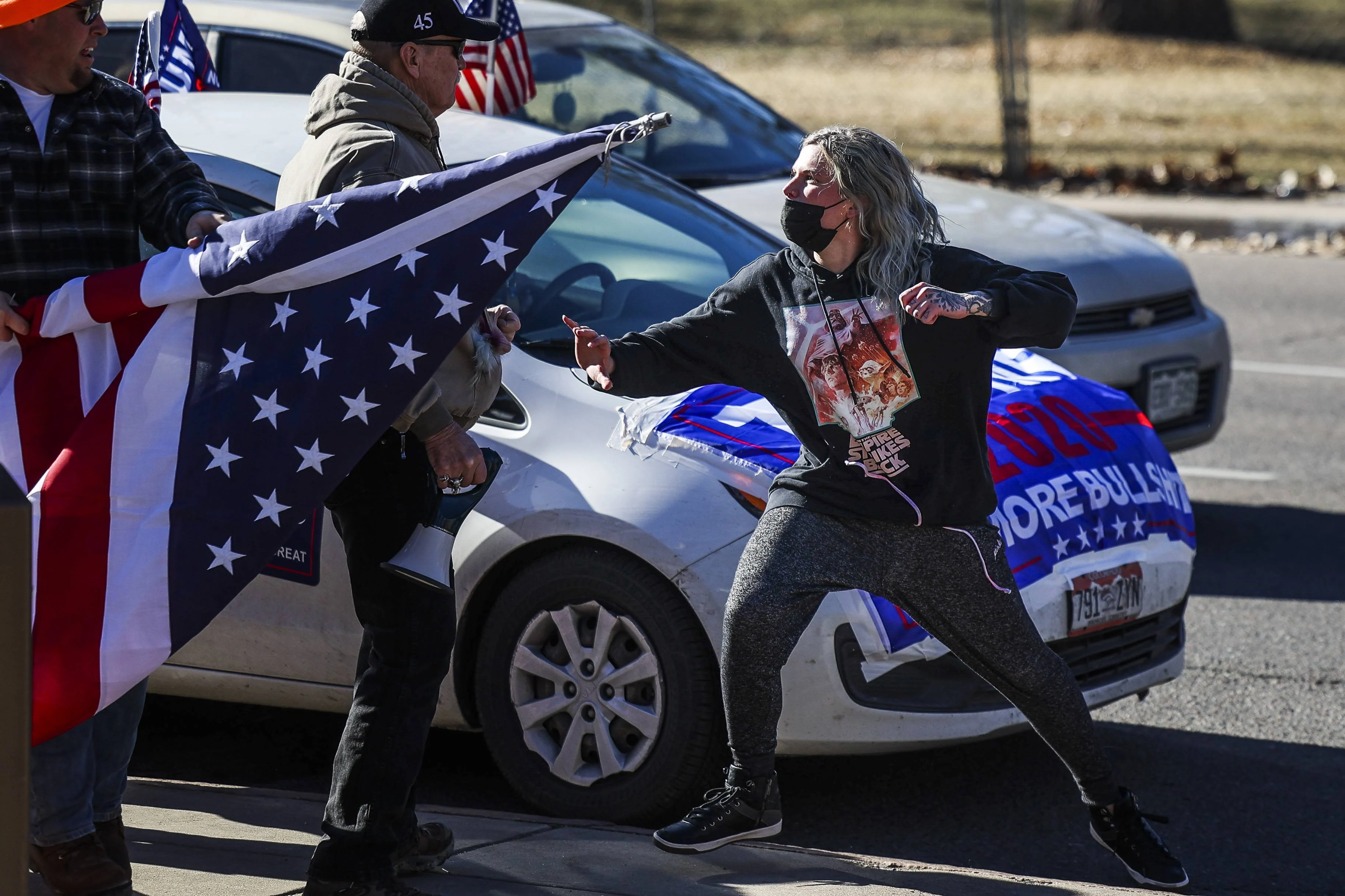 A driver, right, exits her car and attacks a Donald Trump supporter, left, next to the Colorado State Capitol after the supporter started to write on her vehicle window on January 6, 2021 in Denver, Colorado.