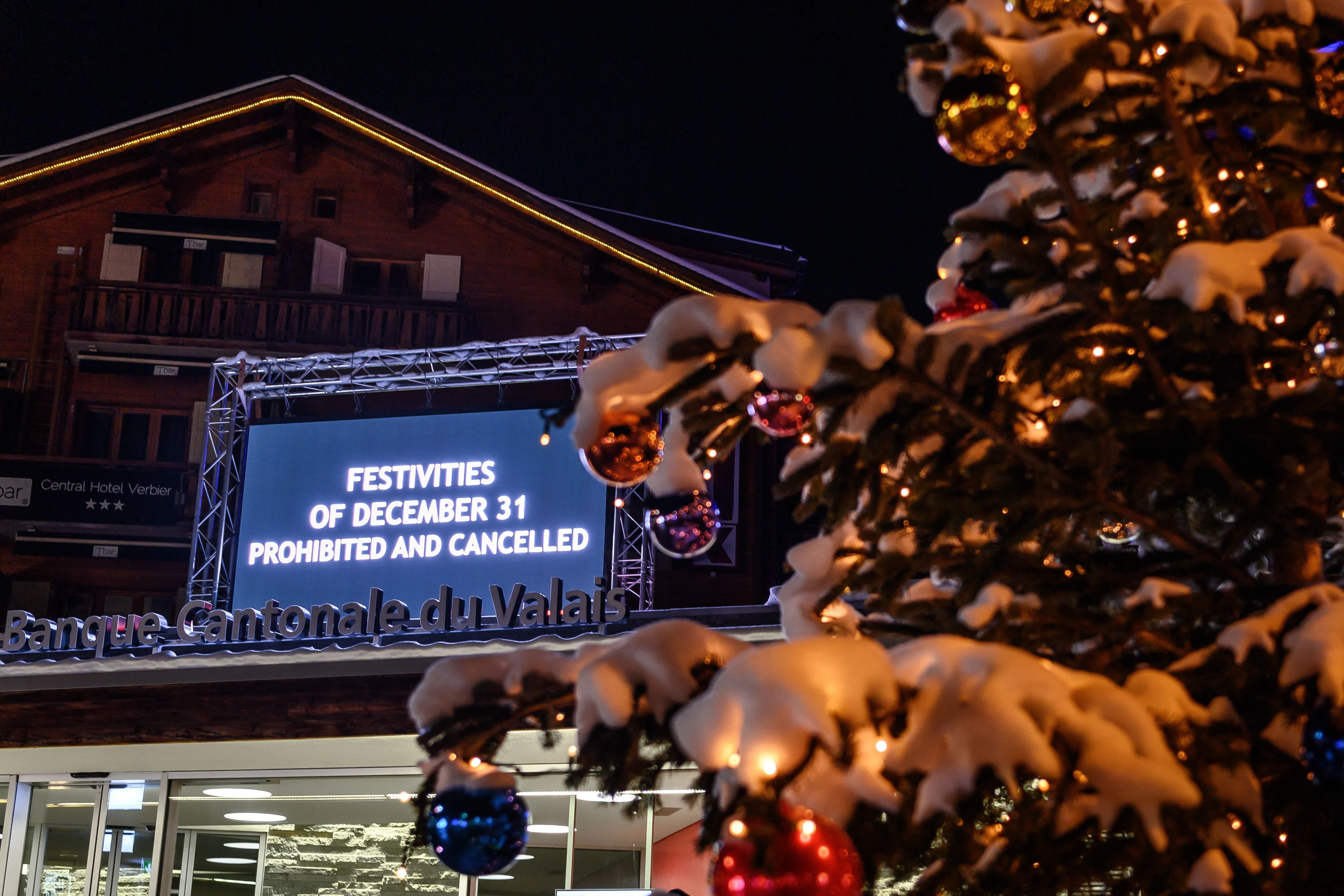 A board is seen at the centre sqaure of the Swiss Alpine resort of Verbier to prevent people from gathering for the New Year on late December 31, 2020.