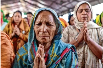A woman pays a tribute to
farmers who lost their lives
during the protest.