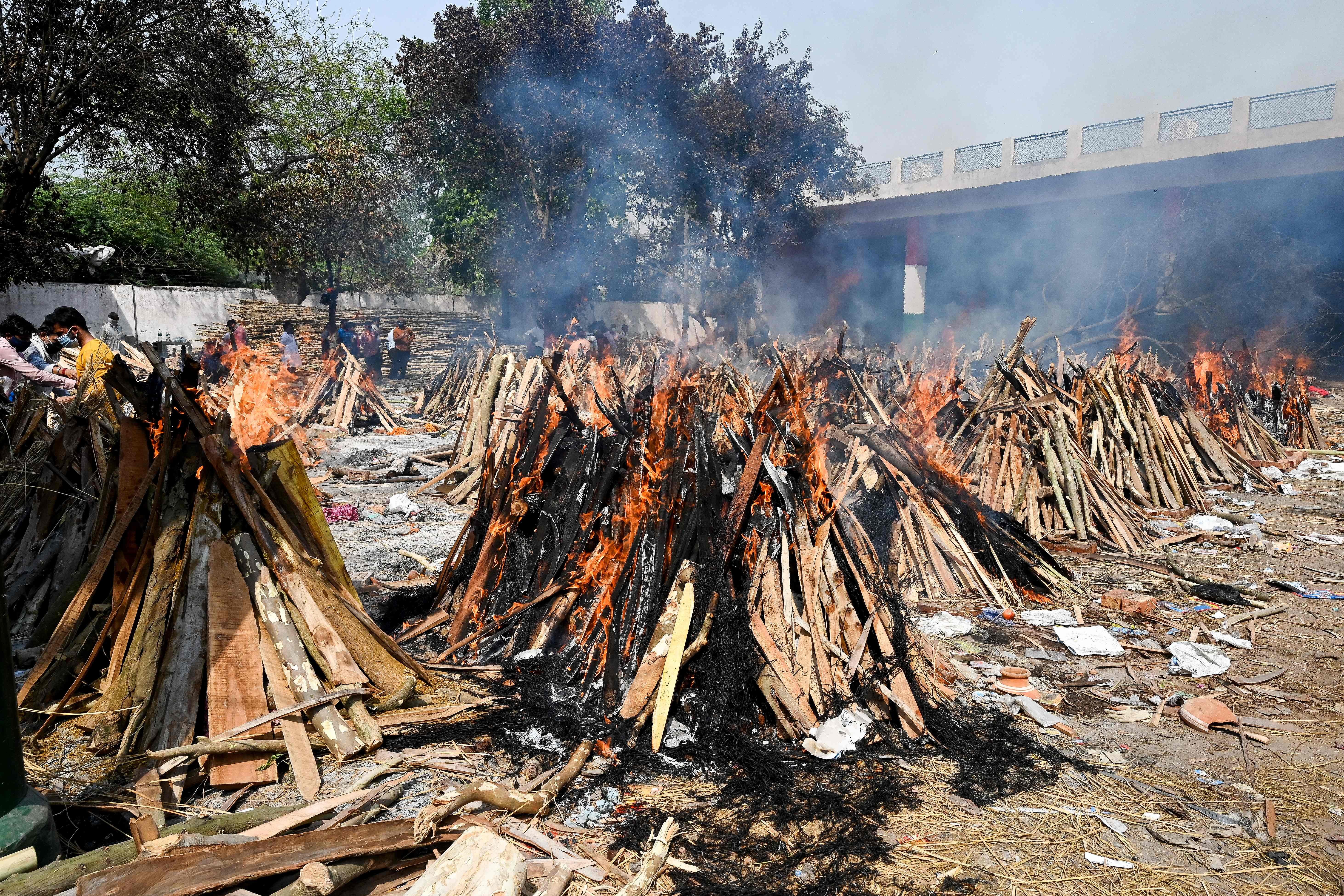 Burning funeral pyres can be seen of the patients who died of the Covid-19 coronavirus at a crematorium in New Delhi on April 27, 2021.