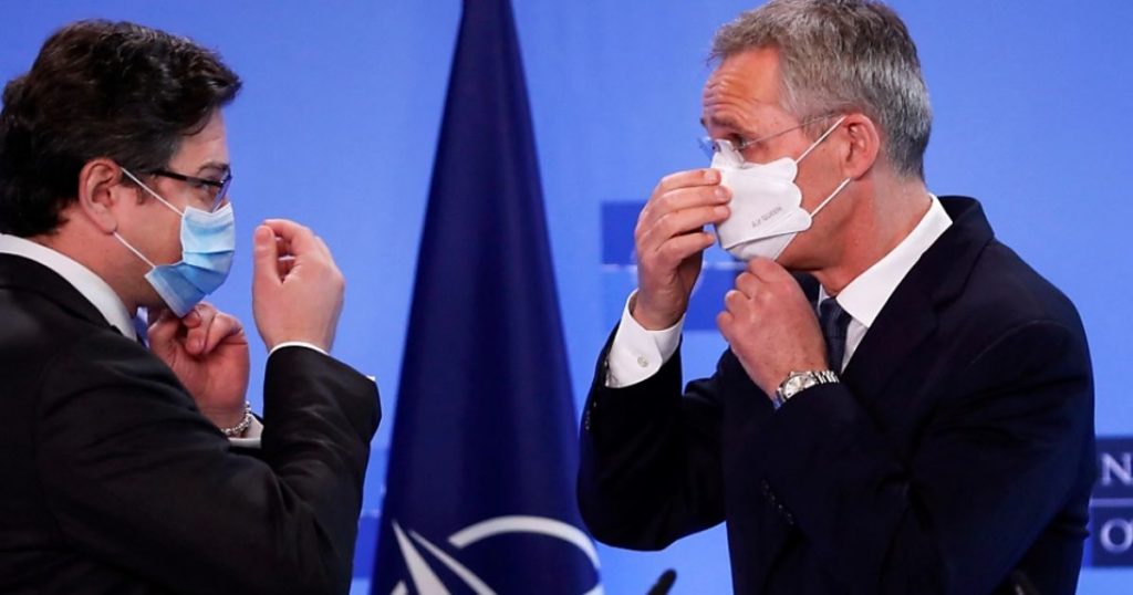 NATO Secretary General Jens Stoltenberg (R) and Ukraine’s 
Foreign Minister Dmytro Kuleba put on their protective face masks after a press conference at NATO headquarters in Brussels. 