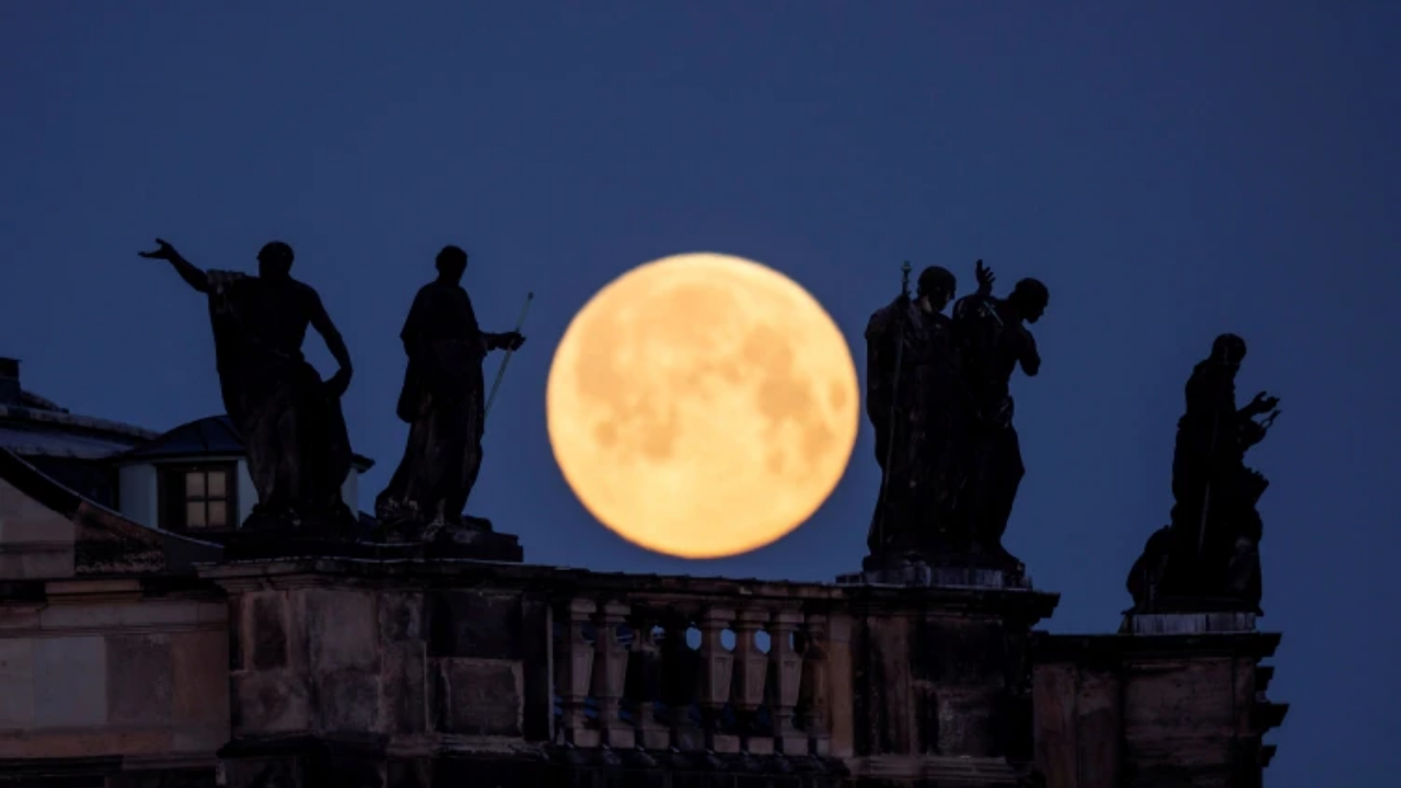 Supermoon is seen behind the sculptures on the roof of the cathedral in Dresden.
