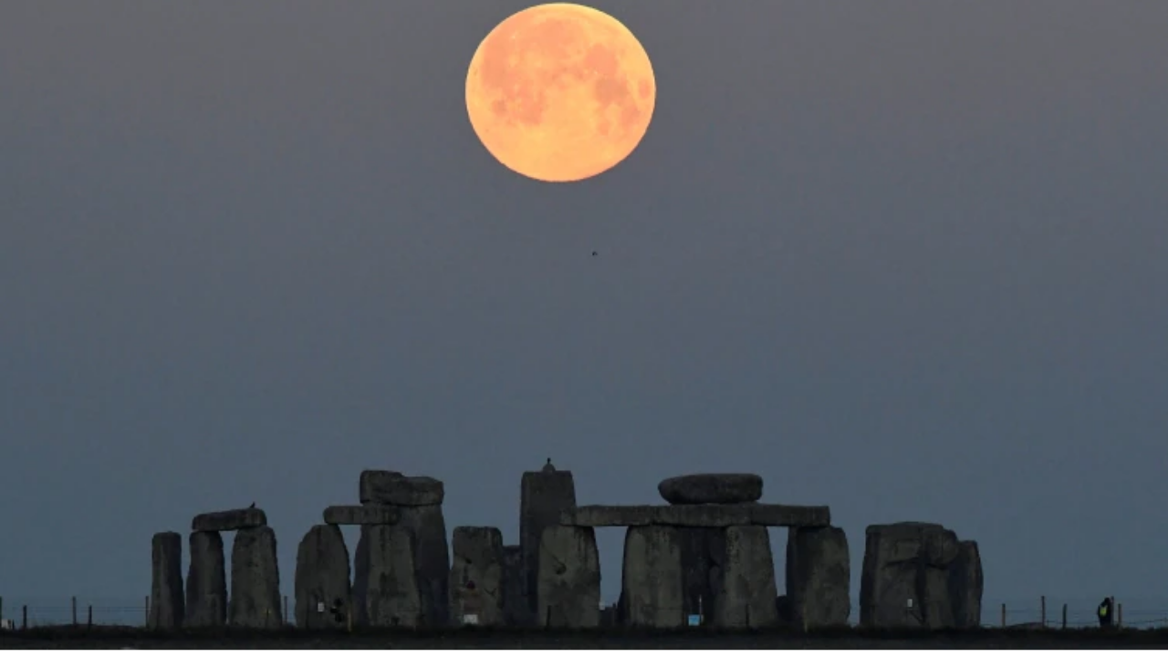 Supermoon sets behind Stonehenge stone circle near Amesbury, Britain.