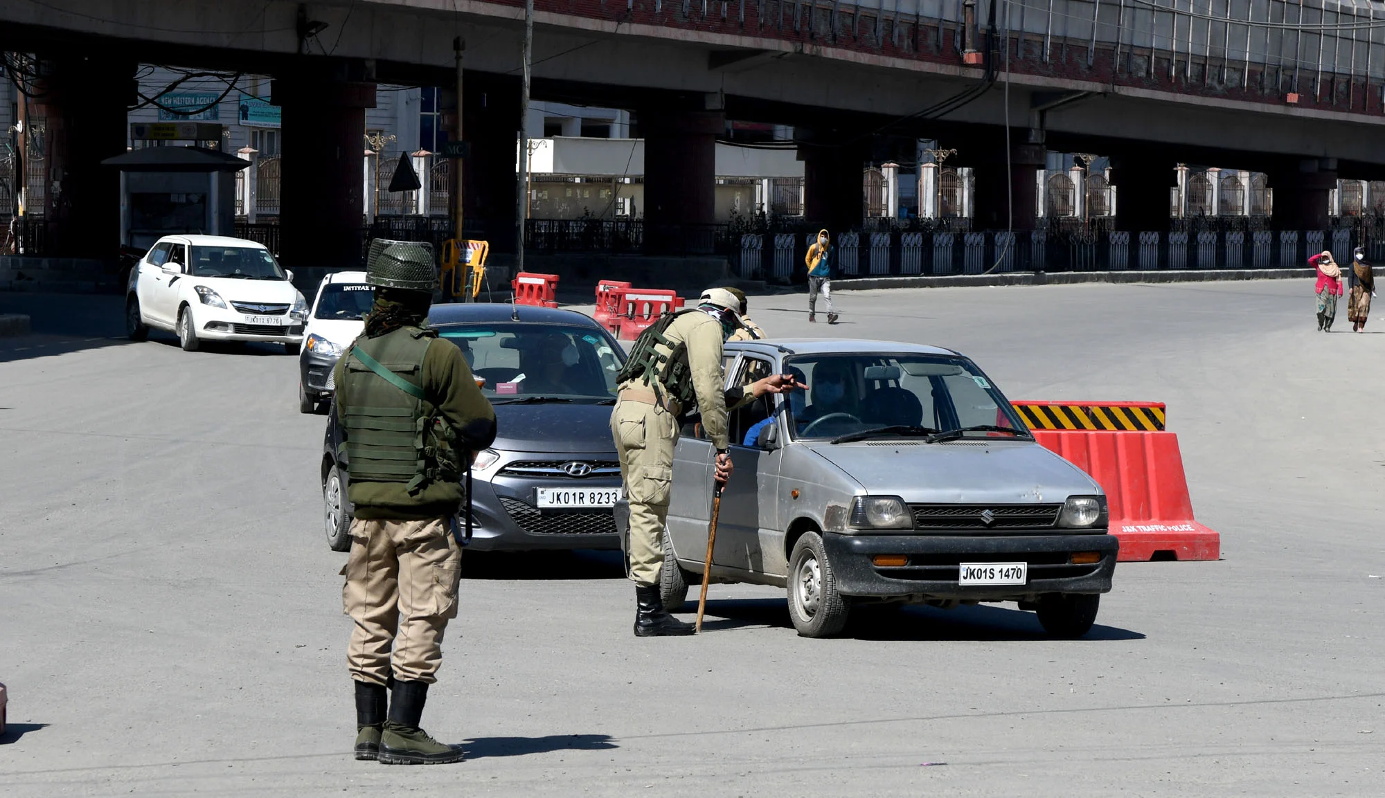Police personnel stop vehicles to check the documents and curfew-pass on the first day of the weekend curfew in the state amid the rise in COVID-19 cases, in Srinagar, Kashmir.