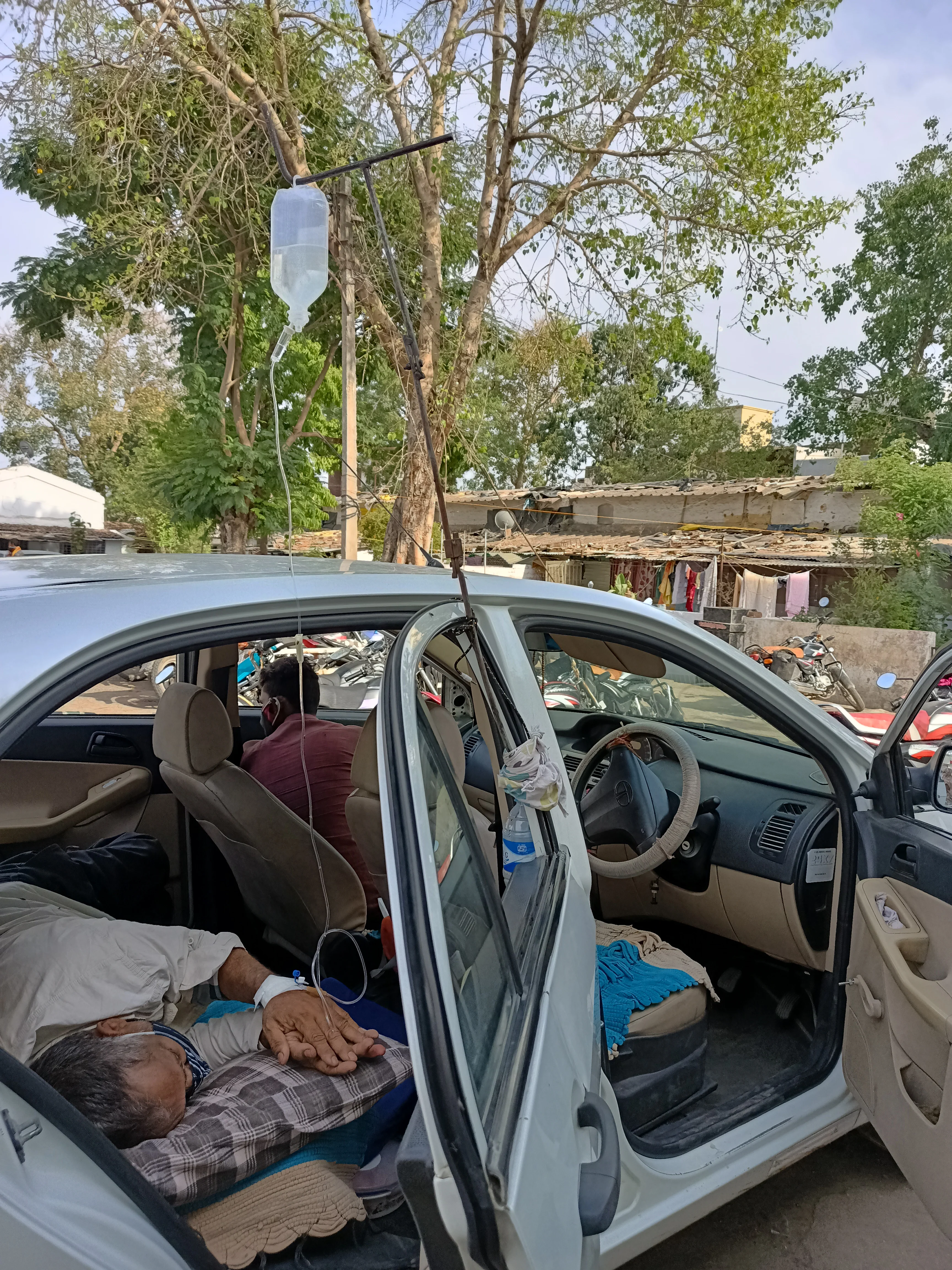 Patient getting treatment in a car outside Sardarpur CHC on Sunday.