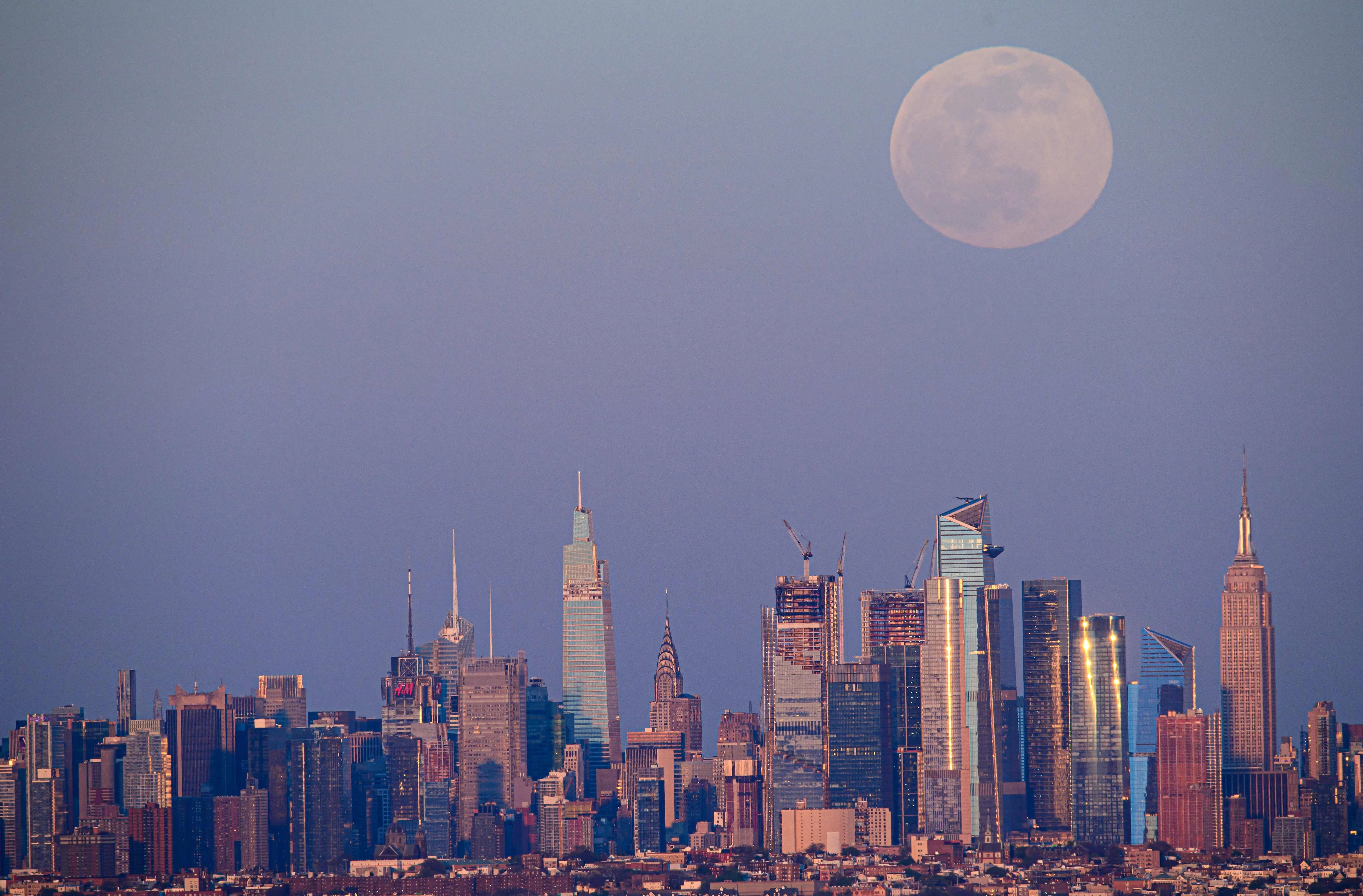 The full moon of April, called the Super Pink Moon, rises over the skyline of Manhattan on April 26, 2021.
