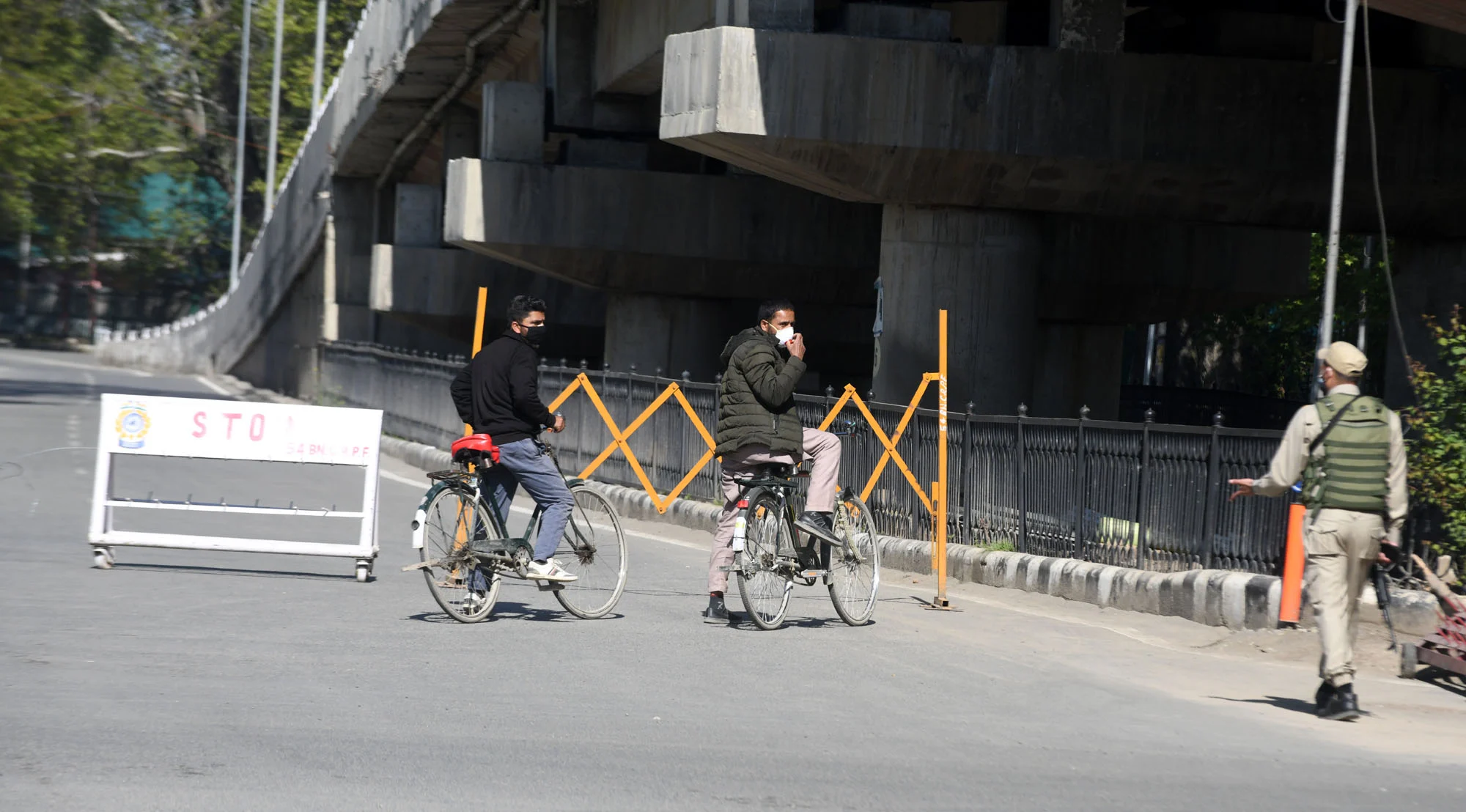 Security personnel stop commuters during the weekend curfew imposed in the wake of rising Covid-19 cases, in Srinagar, Kashmir.