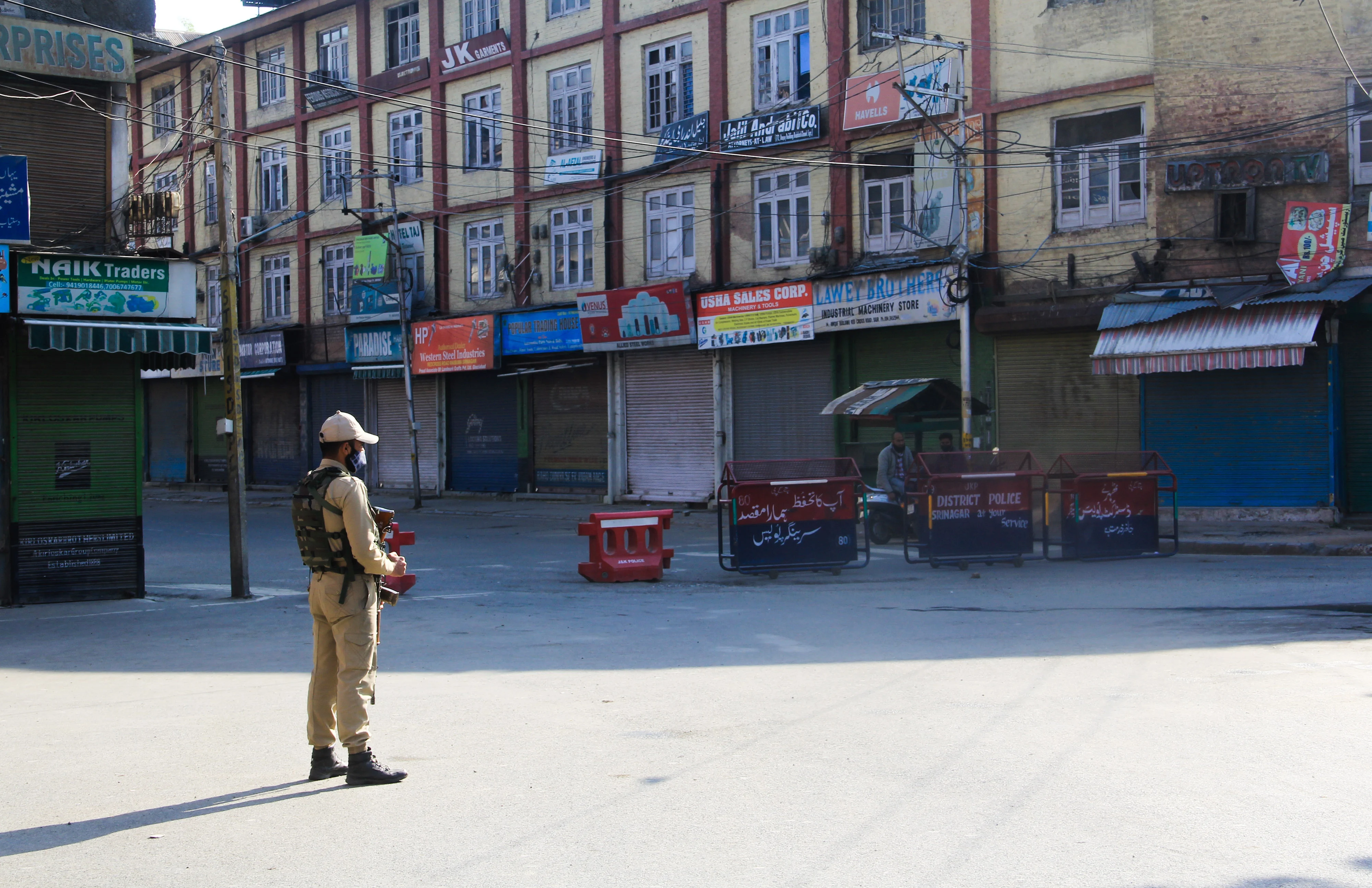 Security man stand guard on a deserted street during corona curfew in Srinagar, Kashmir. As the COVID-19 cases continue to rise the authorities imposed strict Corona curfew across Jammu and Kashmir in order to stop further spread of Coronavirus.