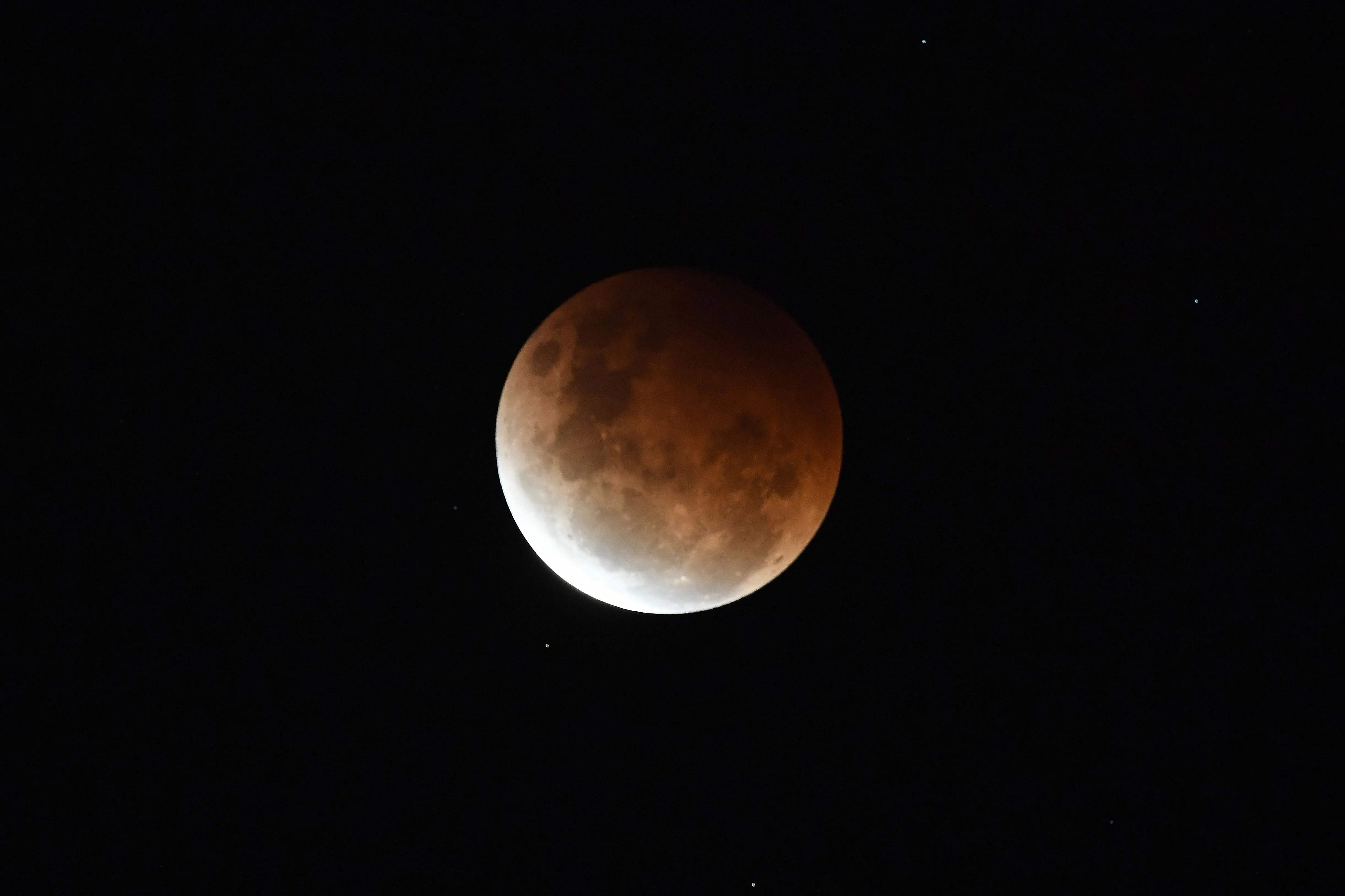 The full moon is seen during the partial eclipse in Sydney on May 26, 2021 as stargazers across the Pacific are casting their eyes skyward to witness a rare "Super Blood Moon".