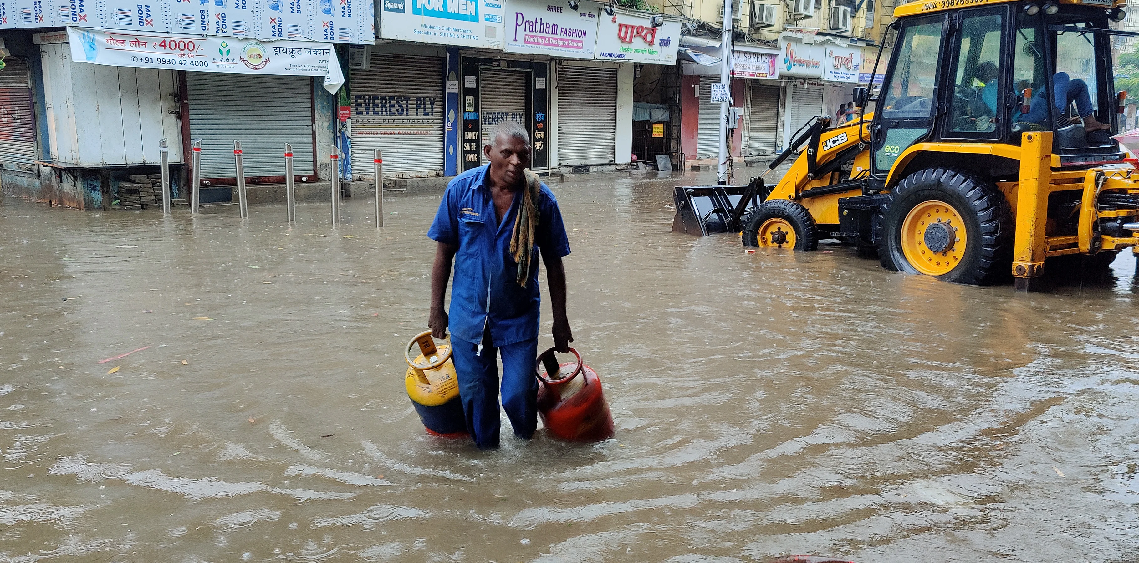 A man wades through a waterlogged street after heavy rainfall in view of Cyclone Tauktae, in Mumbai ?on Monday.