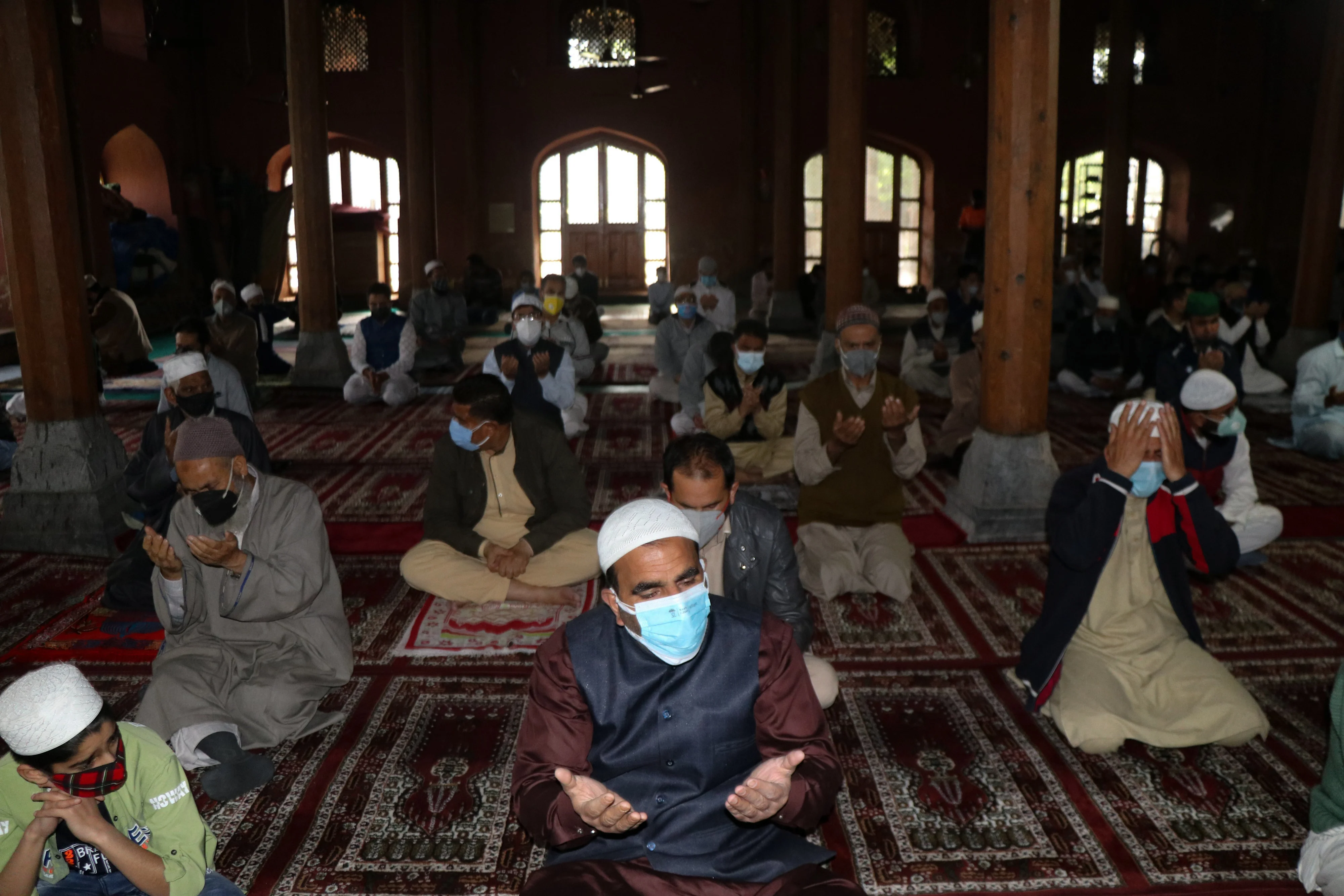 Worshippers wearing protective face masks offer Eid ul-Fitr prayers inside a local mosque to help prevent the spread of Coronavirus in Srinagar, Kashmir.