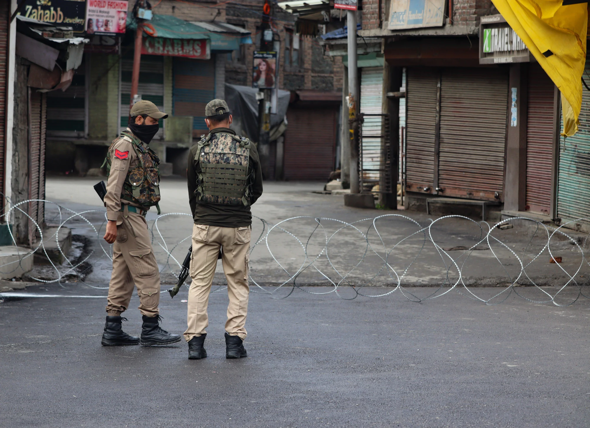 Security personnel stand guard at a deserted street as strict curfew has been imposed amid concerns over the spread of Coronavirus during the Muslim festival of Eid ul-Fitr in Srinagar, Kashmir.