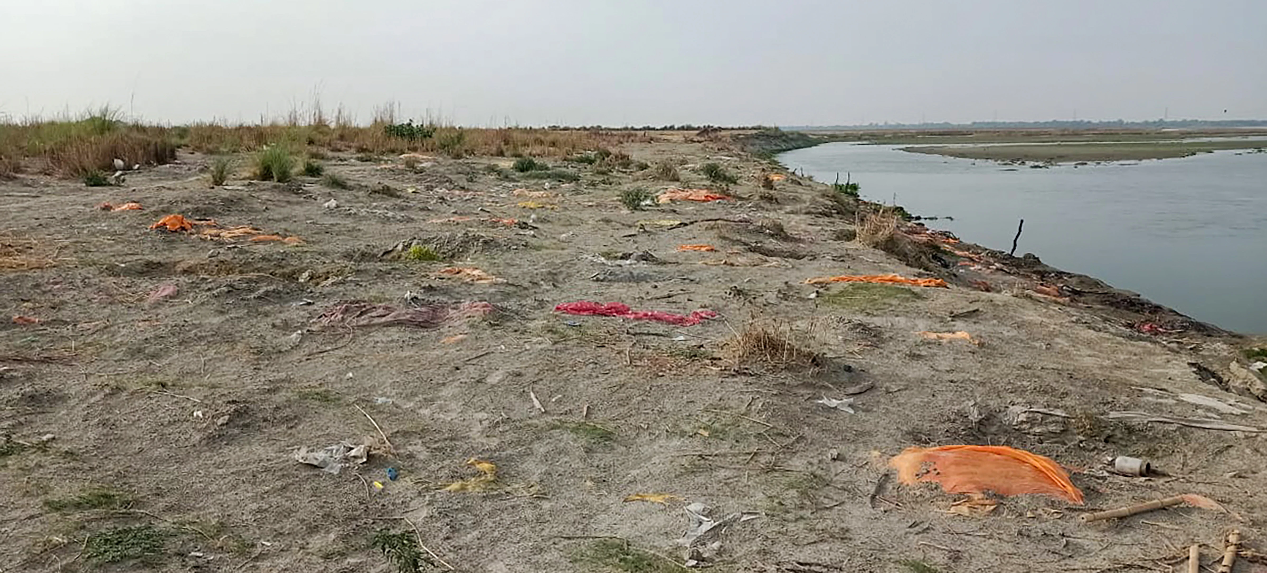 Bodies buried in the sand on the banks of Ganga river, as coronavirus cases surge, in Unnao district