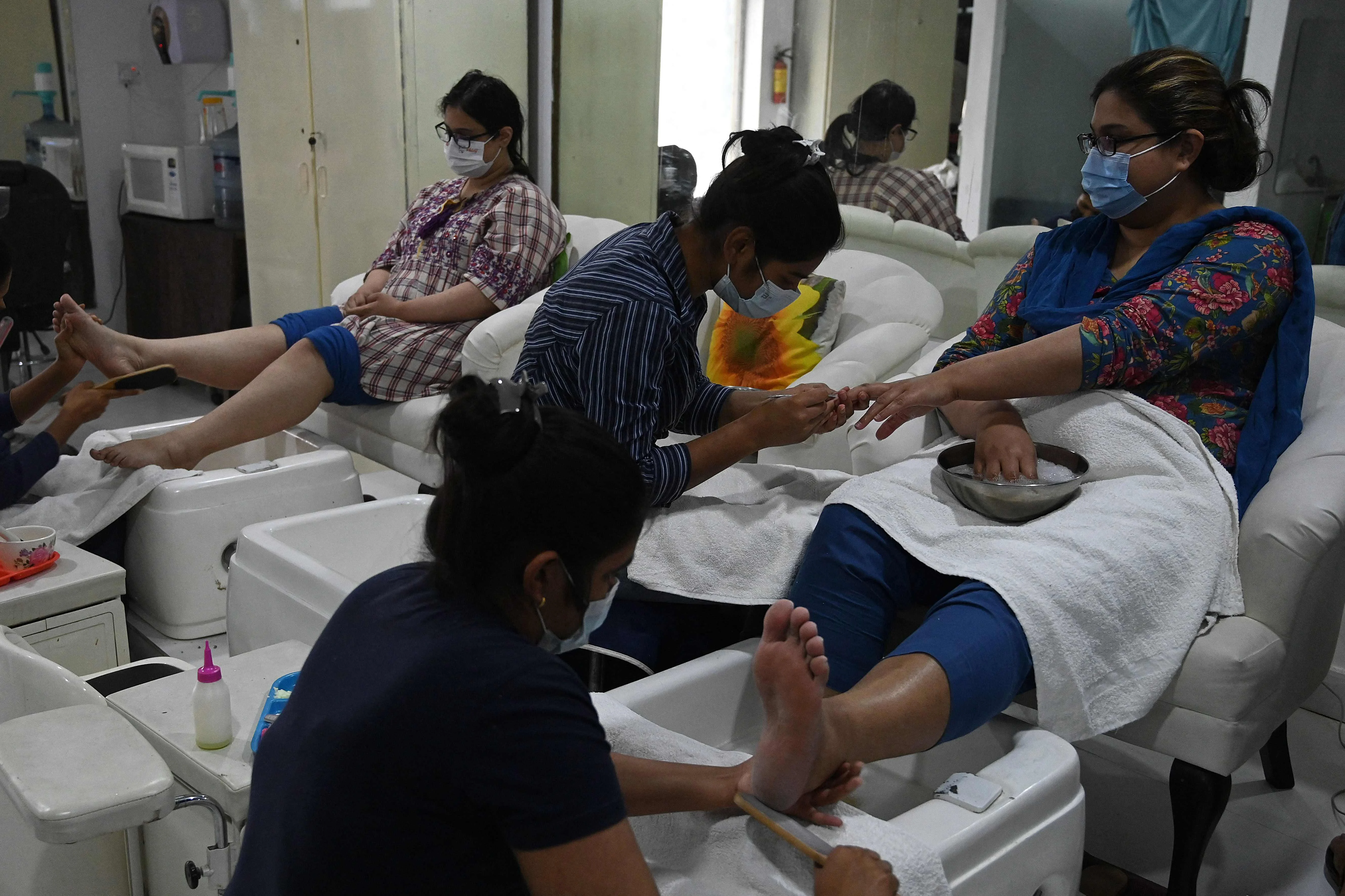 Beauticians attend customers at a beauty salon during the holy month of Ramadan ahead of the Eid ul-Fitr festivities amid the Coronavirus pandemic in Islamabad on May 10, 2021.