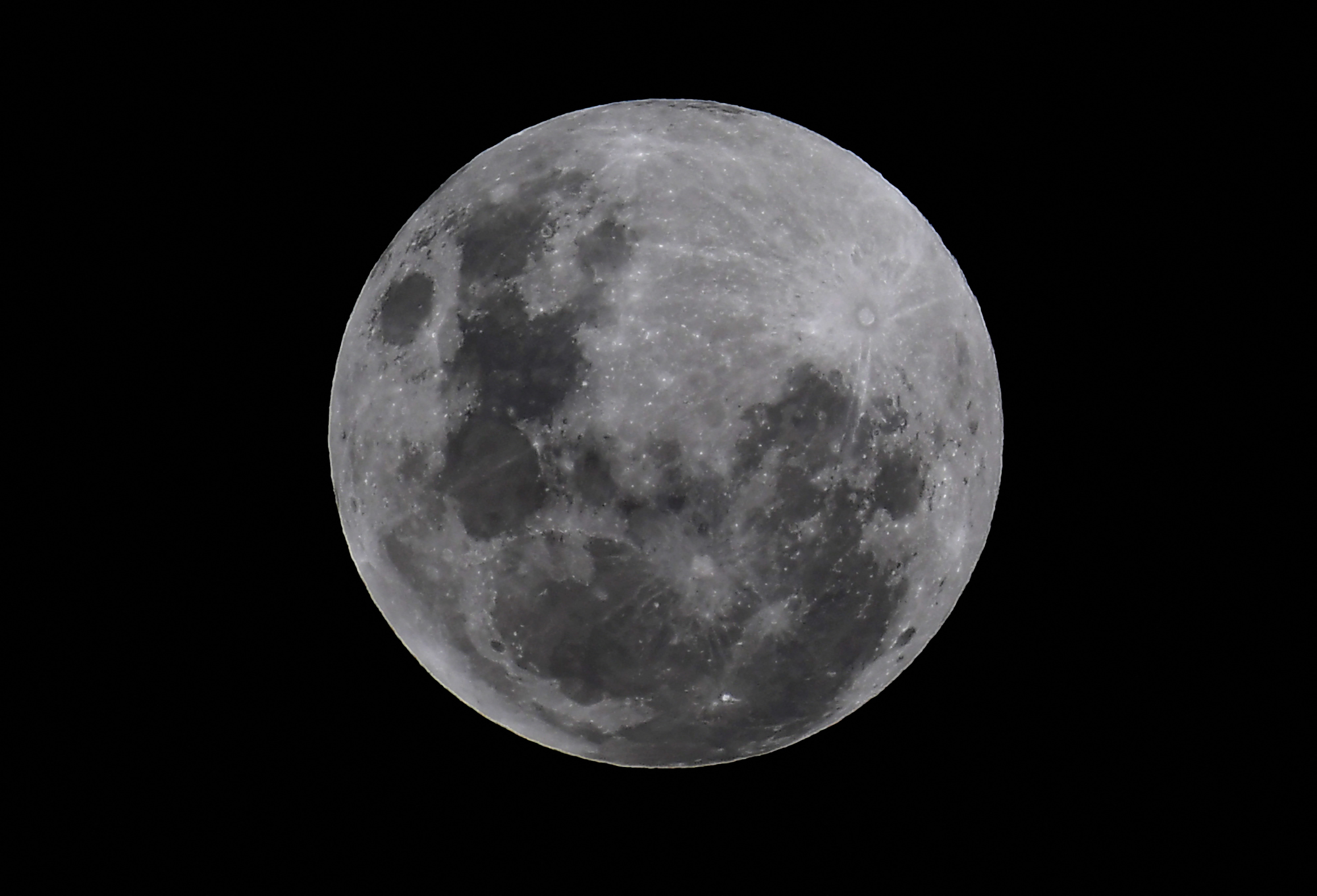 The full super moon is seen before entering the partial eclipse in Melbourne on May 26, 2021 as stargazers across the Pacific are casting their eyes skyward to witness a rare "Super Blood Moon".