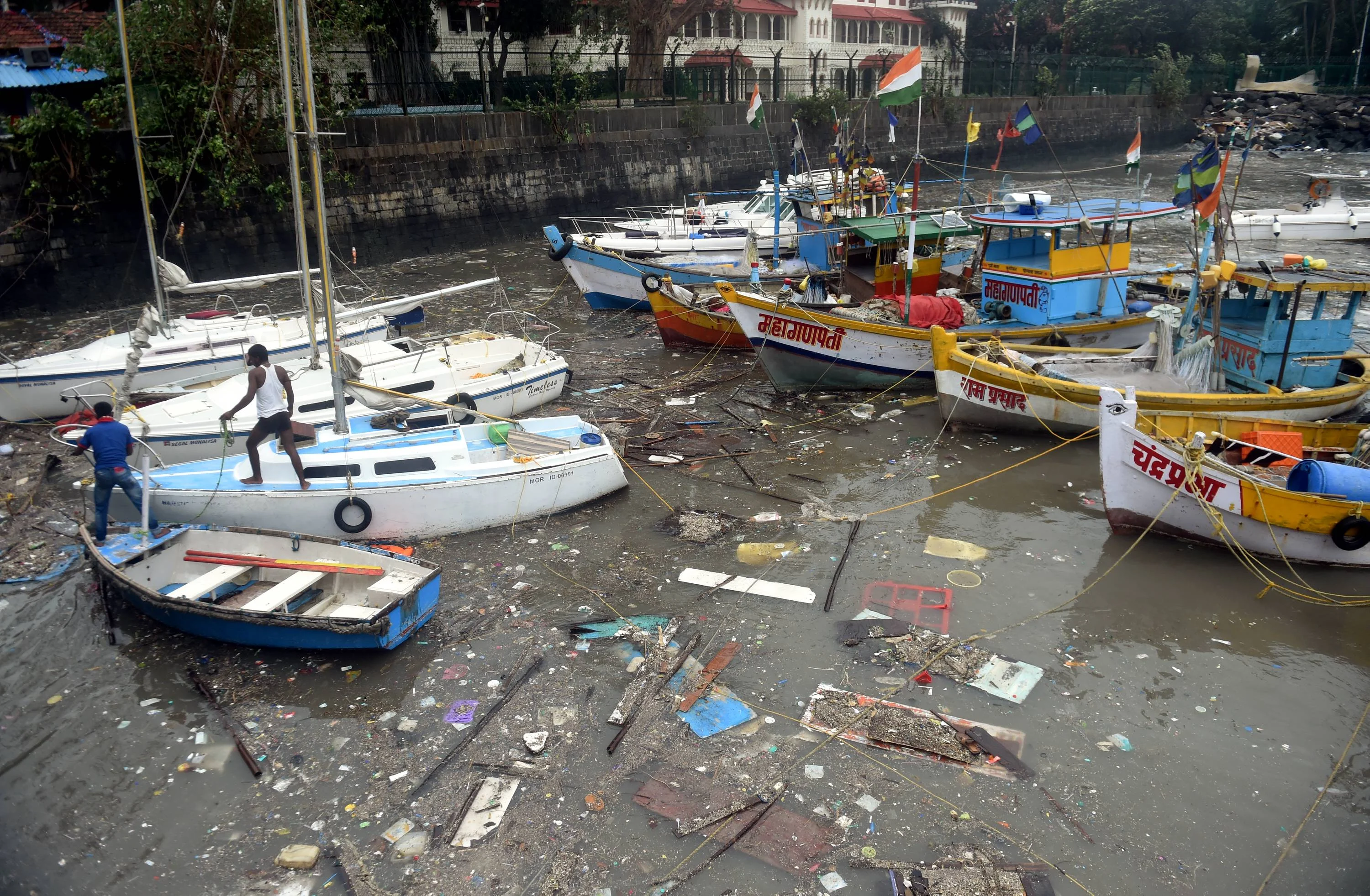 Garbage collects near the boats anchored at Gateway of India in Mumbai, Tuesday,