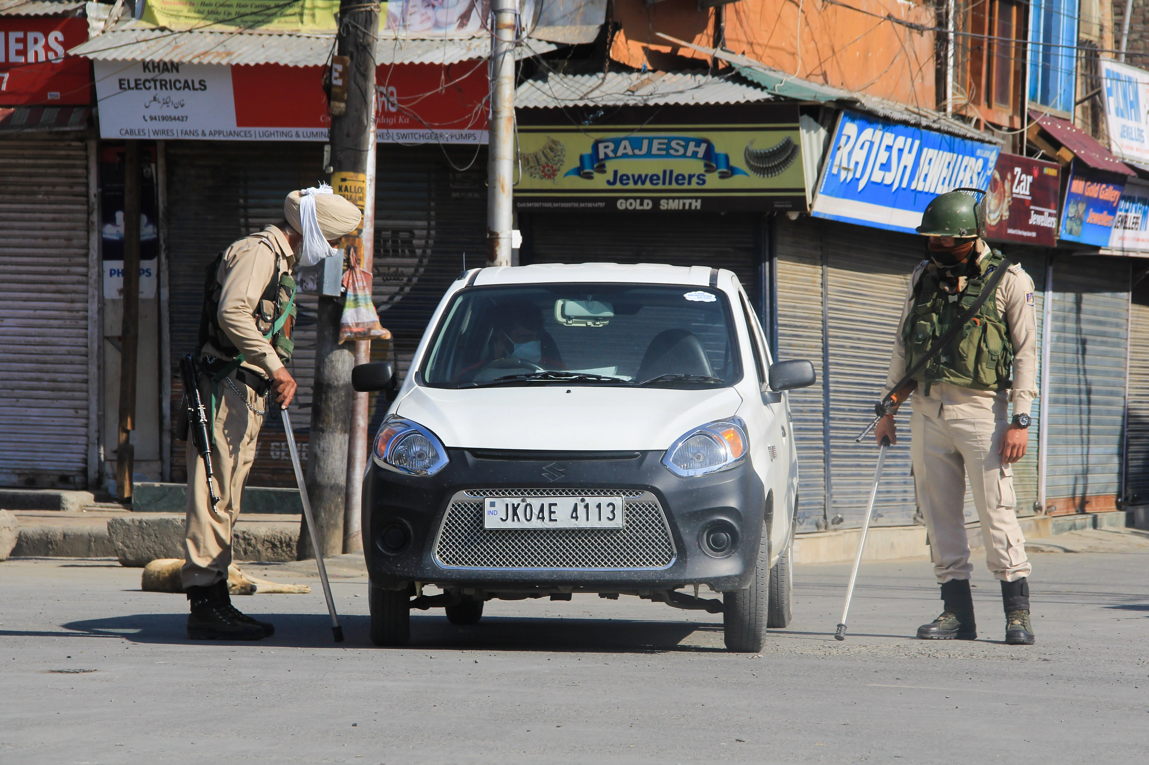 Securitymen stop a car on a street during Corona curfew in Srinagar, Kashmir. As the COVID-19 cases continue to rise the authorities imposed strict Corona curfew across Jammu and Kashmir in order to stop further spread of Coronavirus.