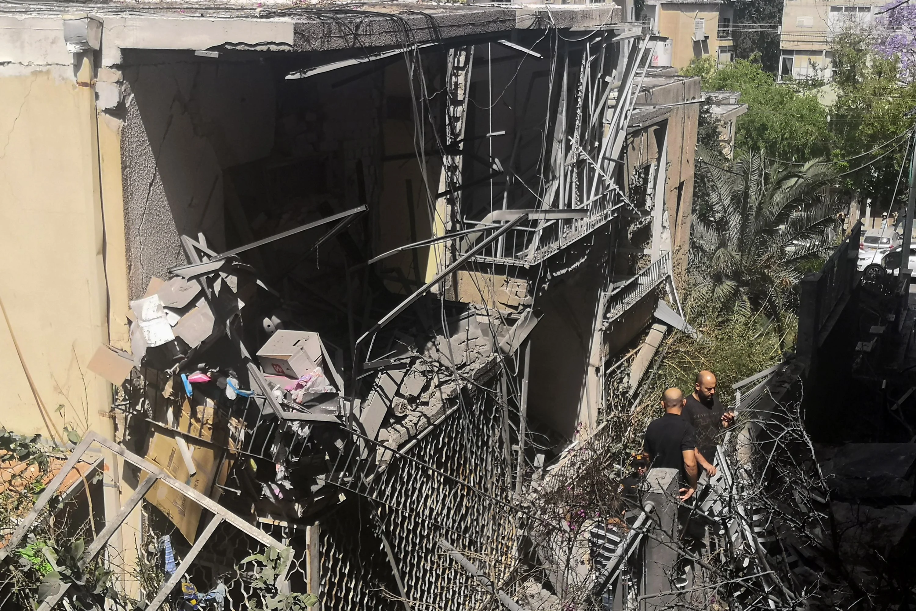 Israeli residents inspect a damaged house in the Tel Aviv suburb of Givatayim on May 12, 2021, following a nights rocket strike, the first in the neighbourhoods history. - Tel Aviv, 70 kilometres (40 miles) from Gaza City, had been largely spared the brunt of rockets fired by Palestinian militants in the territory, under Israeli blockade for 15 years.
