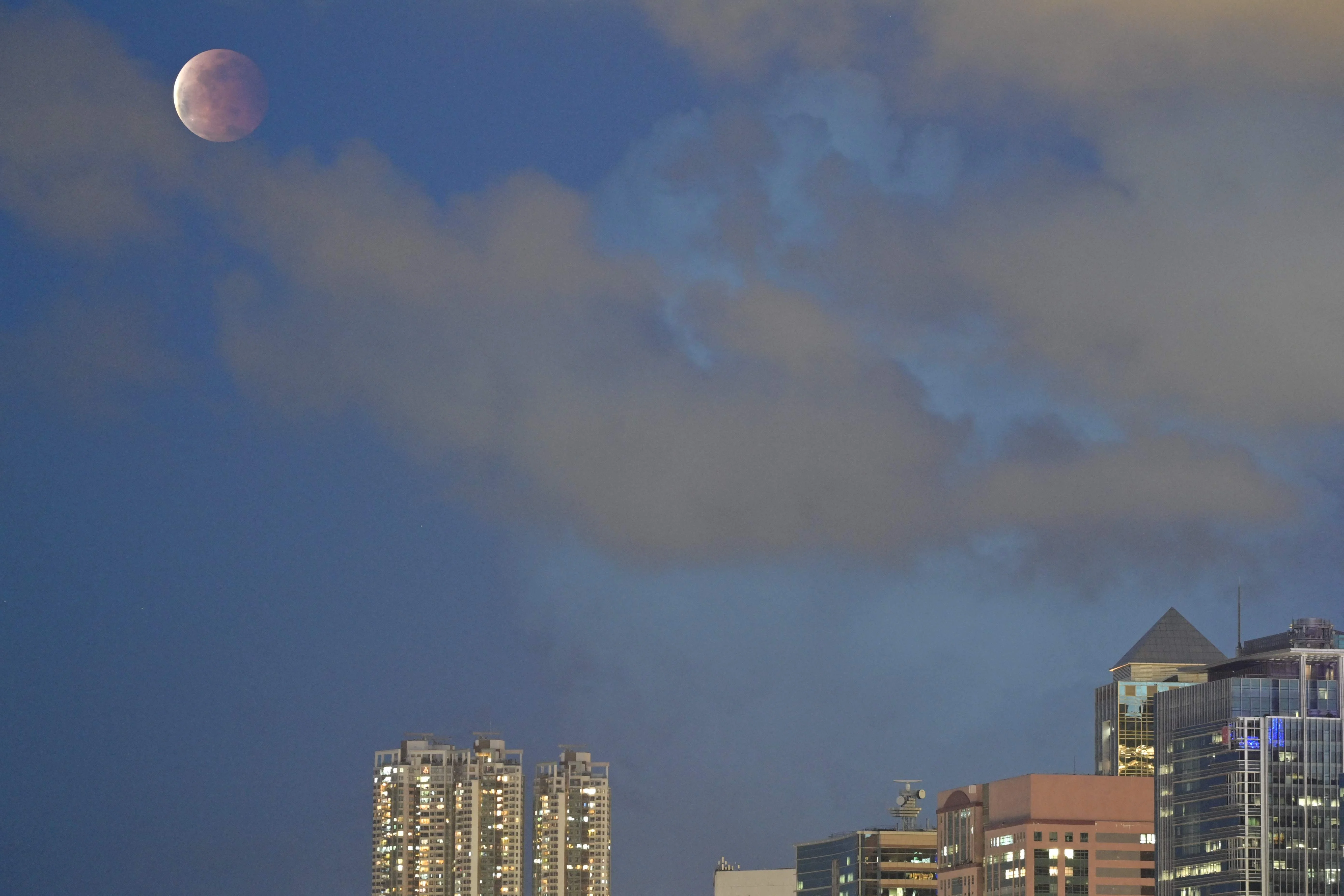 The moon is pictured above Hong Kong on May 26, 2021, during a total lunar eclipse as stargazers across the Pacific are casting their eyes skyward to witness a rare "Super Blood Moon".