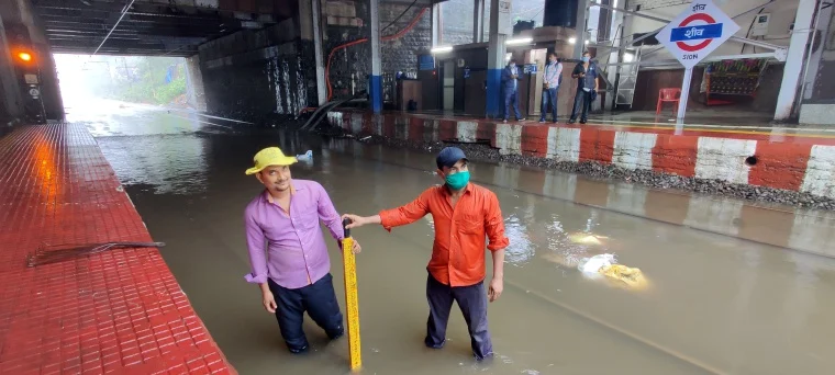 Railway workers at waterlogged Sion station