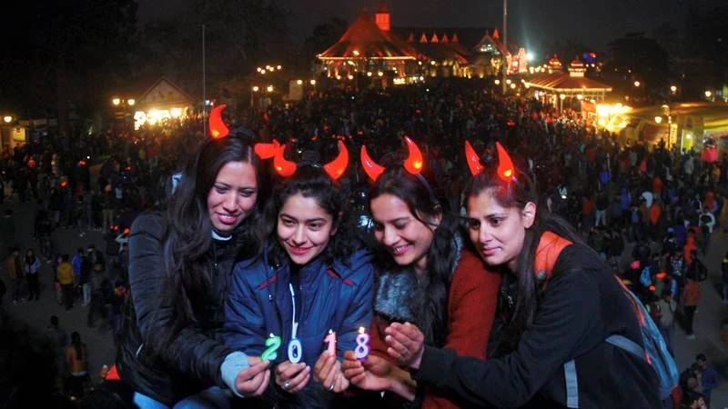 Shimla: Girls hold candles of 2018 to welcome the New Year at Ridge in Shimla. PTI Photo