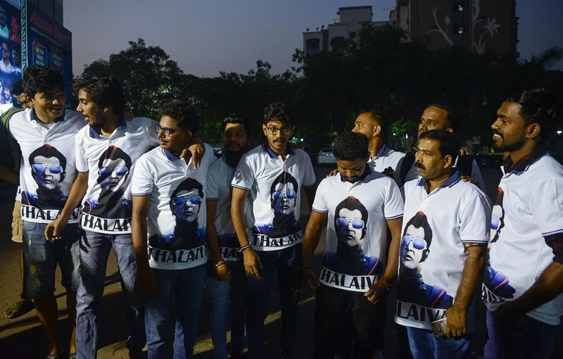 Indian fans wear T-shirt displaying the image of Bollywood star Rajinikanth as they celebrate before attending the early morning show of his new Tamil-language film “2.0” on the first day of its release in Mumbai on November 29, 2018. (Photo by PUNIT PARANJPE / AFP)