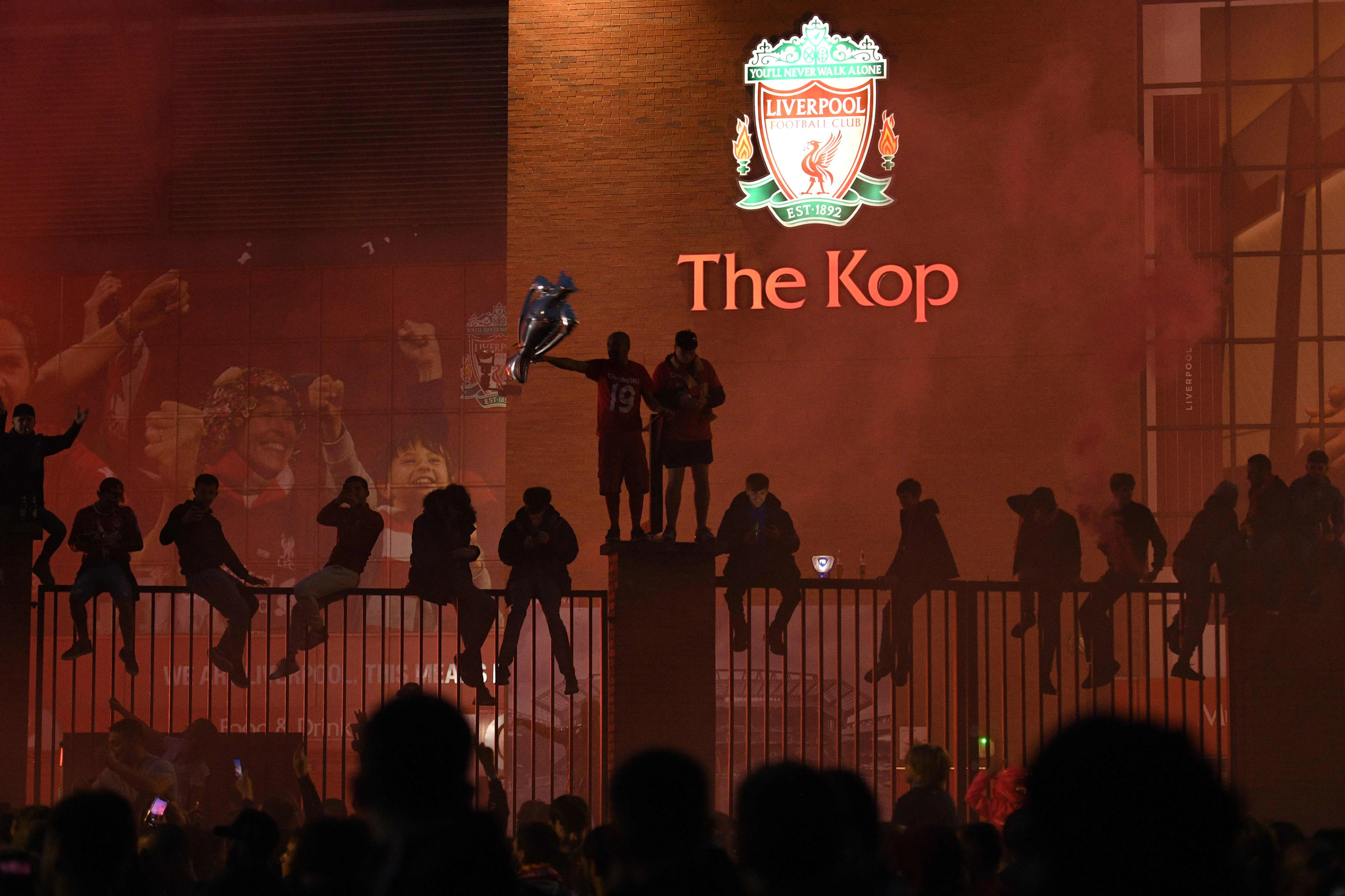 Liverpool fans celebrate outside Anfield in Liverpool, north west England on July 22, 2020 after Liverpools final home English Premier League football match of the season against Chelsea after which the team was presented with the Premier League trophy