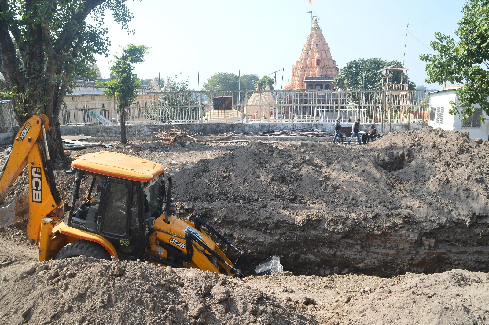 A JCB machine digs the surface at the Mahakal temple complex for the expansion of the temple premises under Smart City Project