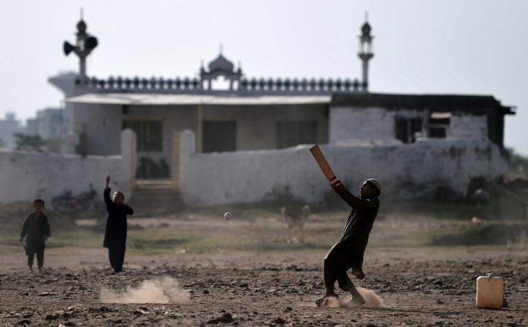 Afghan refugee children play cricket at a refugee camp in Islamabad on Oct 18, 2018.  | AAMIR QURESHI/AFP
