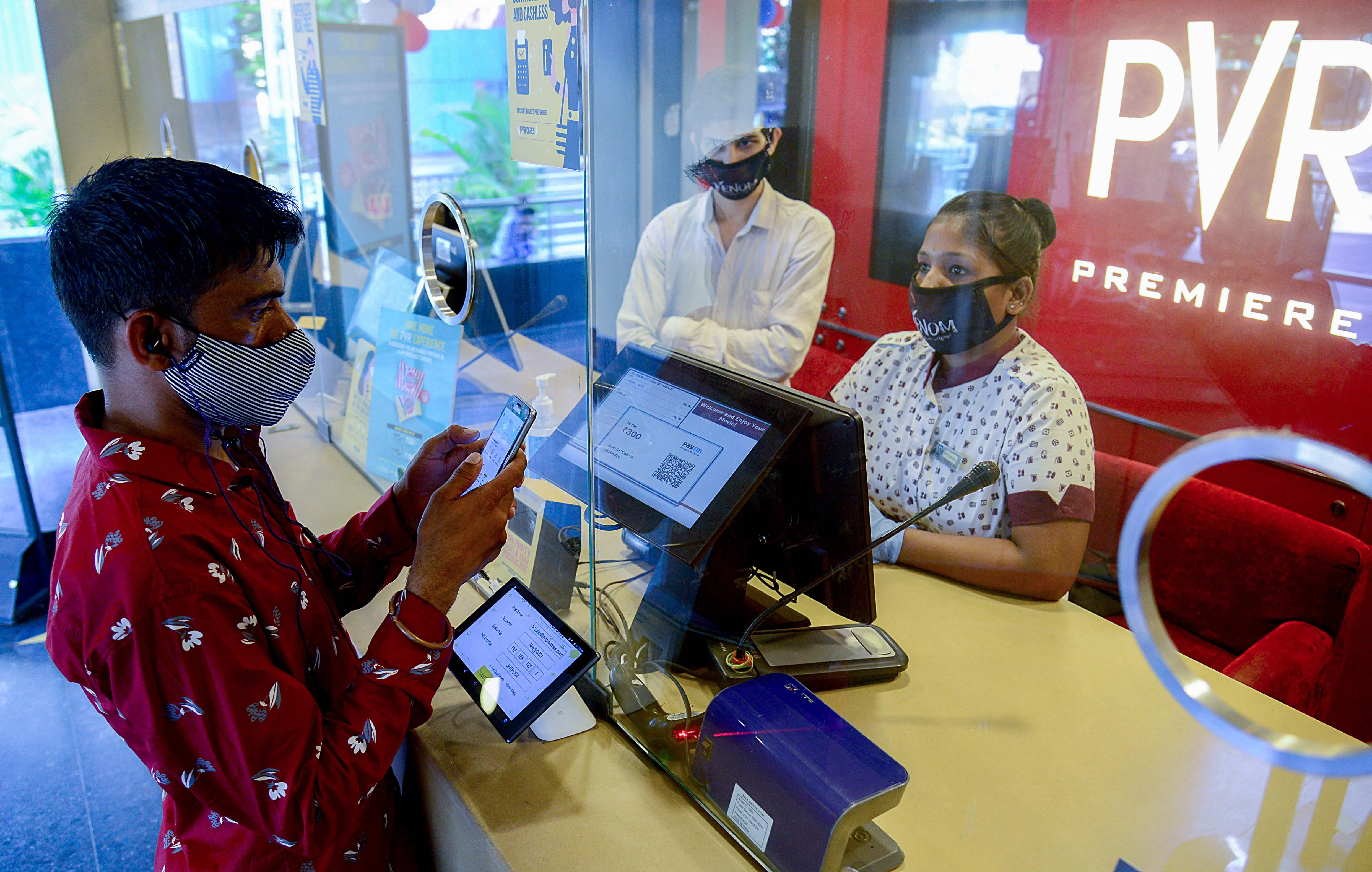 Moviegoers buy movie tickets from the box office of a cinema theatre in Mumbai on October 22, 2021 as cinemas reopened weeks after the Covid-19 coronavirus lockdown