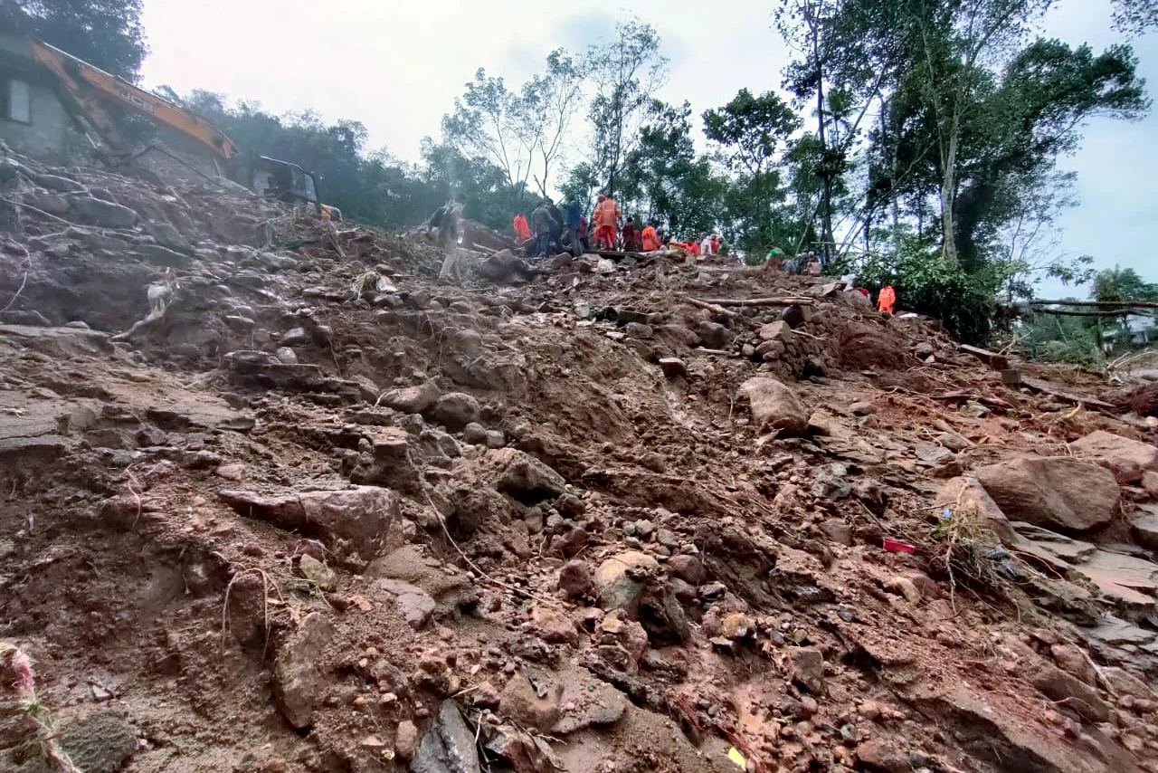 NDRF personnel clear debris caused by a landslide during search and rescue operations at a flood-affected area, at Kokkayar, in Idukki on Sunday.