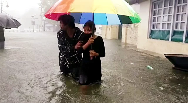 Uttarakhand, Oct 19 (ANI): Commuters travel through a waterlogged road as Nainital Lake overflows and floods the streets due to incessant rainfall, in Nainital on Tuesday. (ANI Photo)