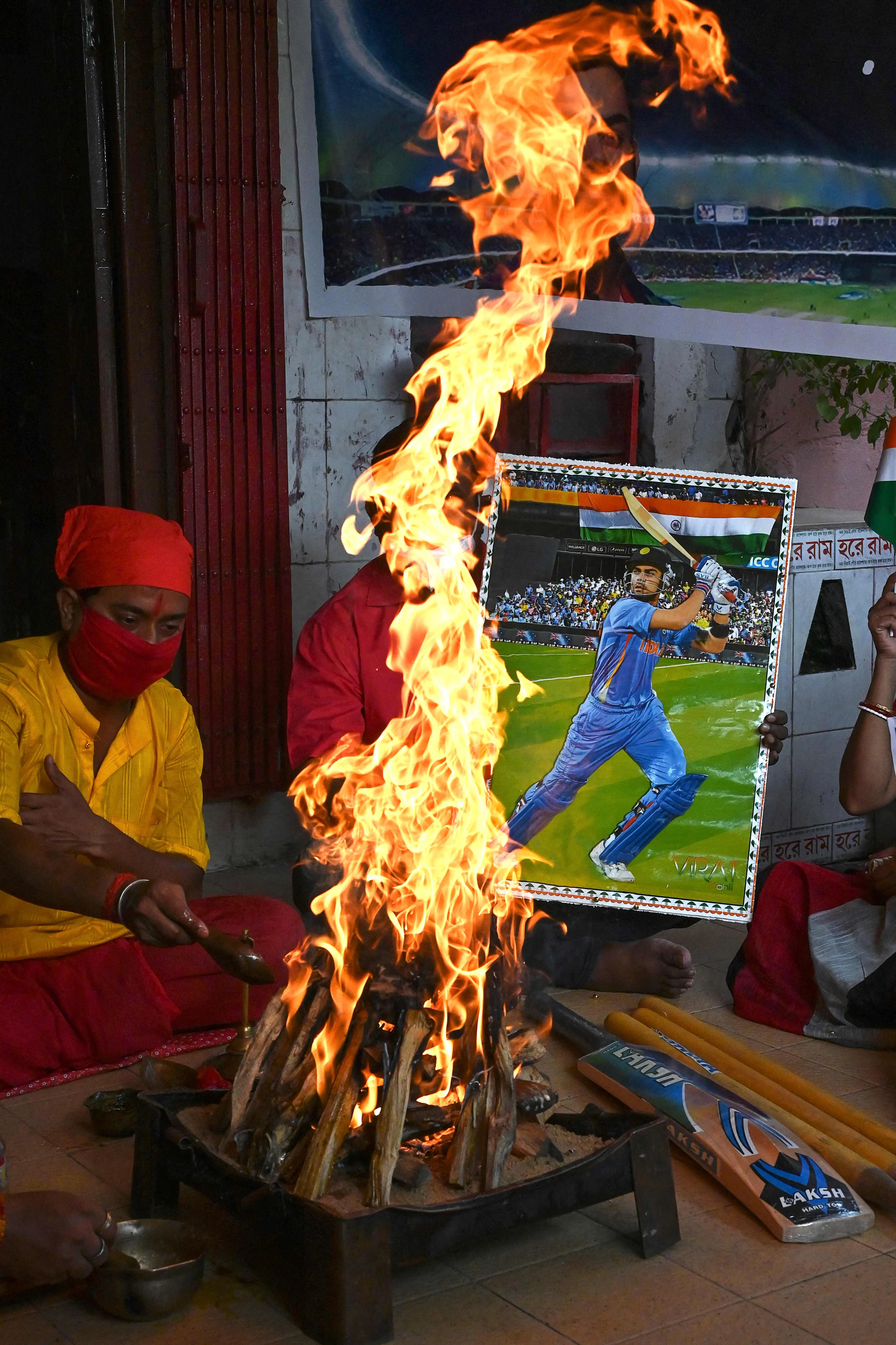 Cricket fans hold a placard with the picture of Indias captain Virat Kohli (R) as they perform rituals wishing the victory of the Indian cricket team ahead of their ICC T20 World Cup 2021 cricket match against Pakistan played in Dubai, in Kolkata on October 24, 2021.