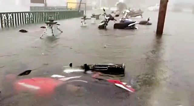 Vehicles get submerged on the waterlogged road as Nainital Lake overflows and floods the streets due to incessant rainfall, in Nainital on Tuesday. (ANI Photo)