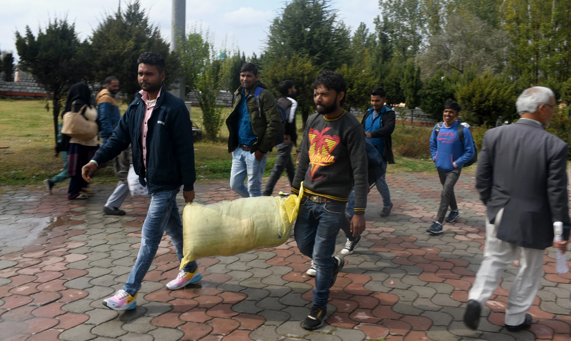 Group of Migrant workers walk towards a railway station in Srinagar to return to their home after fresh of violence against civillians including non locals in the past week across Kashmir
