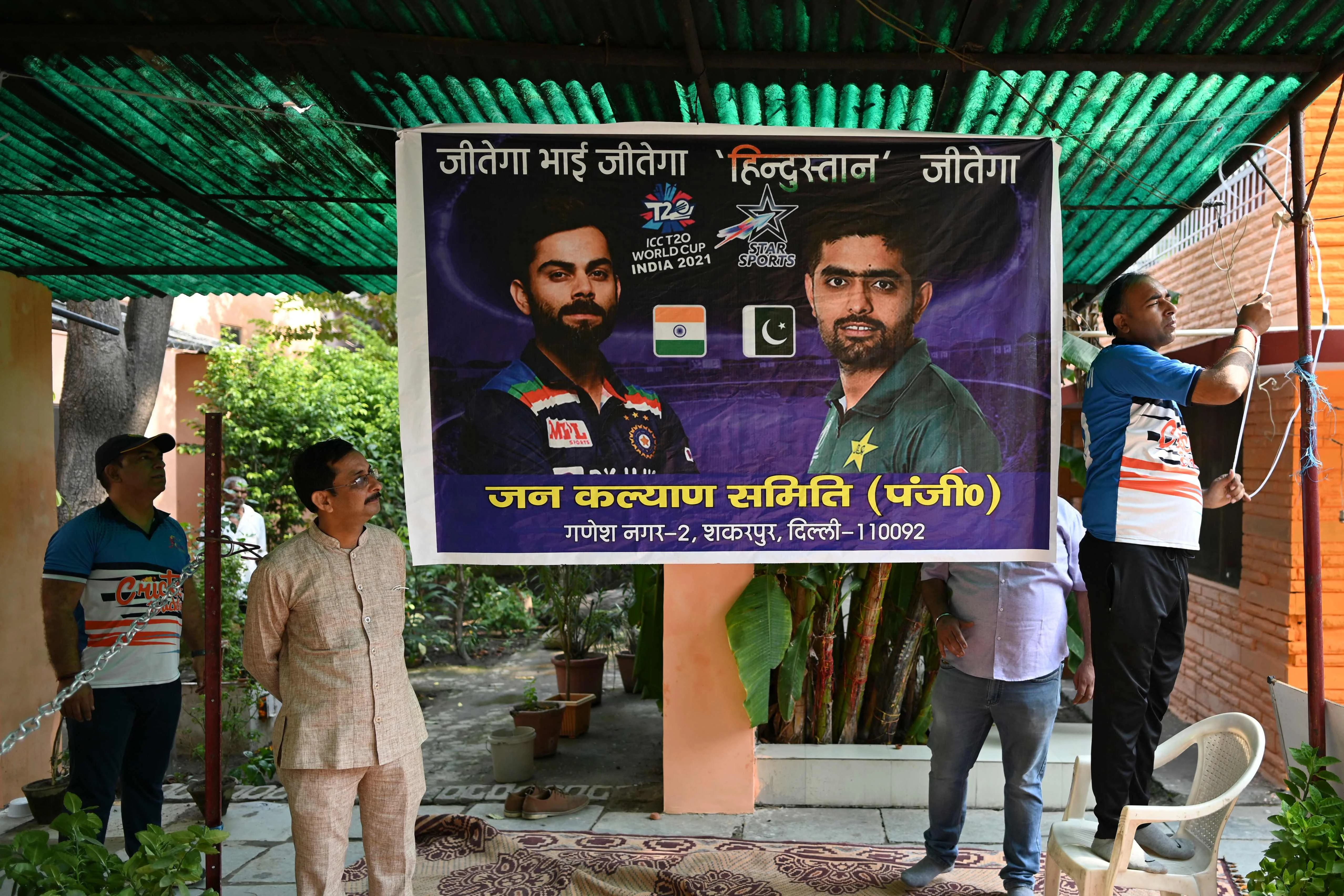 Cricket fans ties a banner with the pictures of Indias captain Virat Kohli (L) and Pakistans captain Babar Azam (R) before performing prayers wishing the victory of the Indian cricket team ahead of their ICC T20 World Cup 2021 cricket match against Pakistan played in Dubai, in New Delhi on October 24, 2021.
